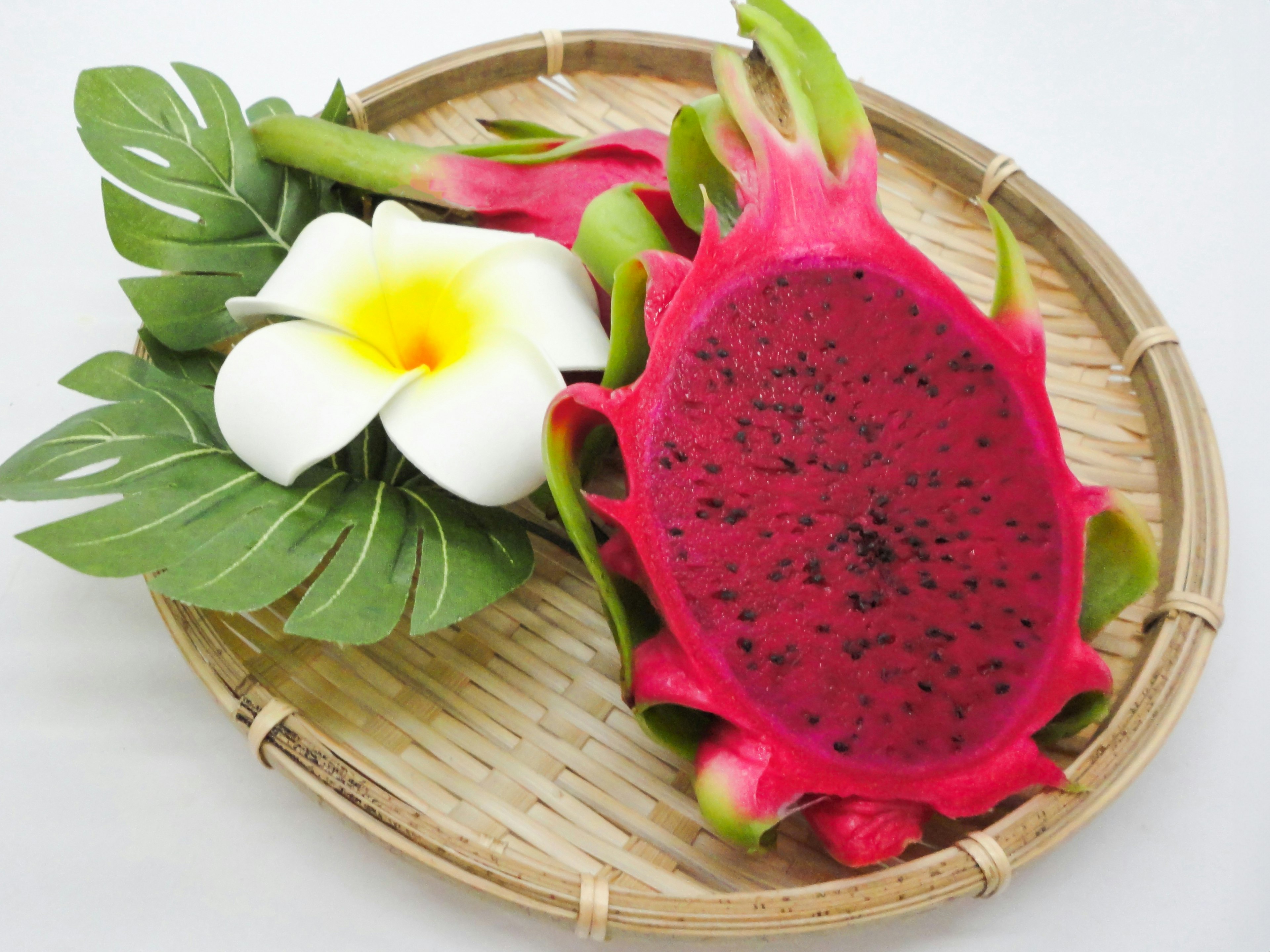 Colorful dragon fruit with a white plumeria flower