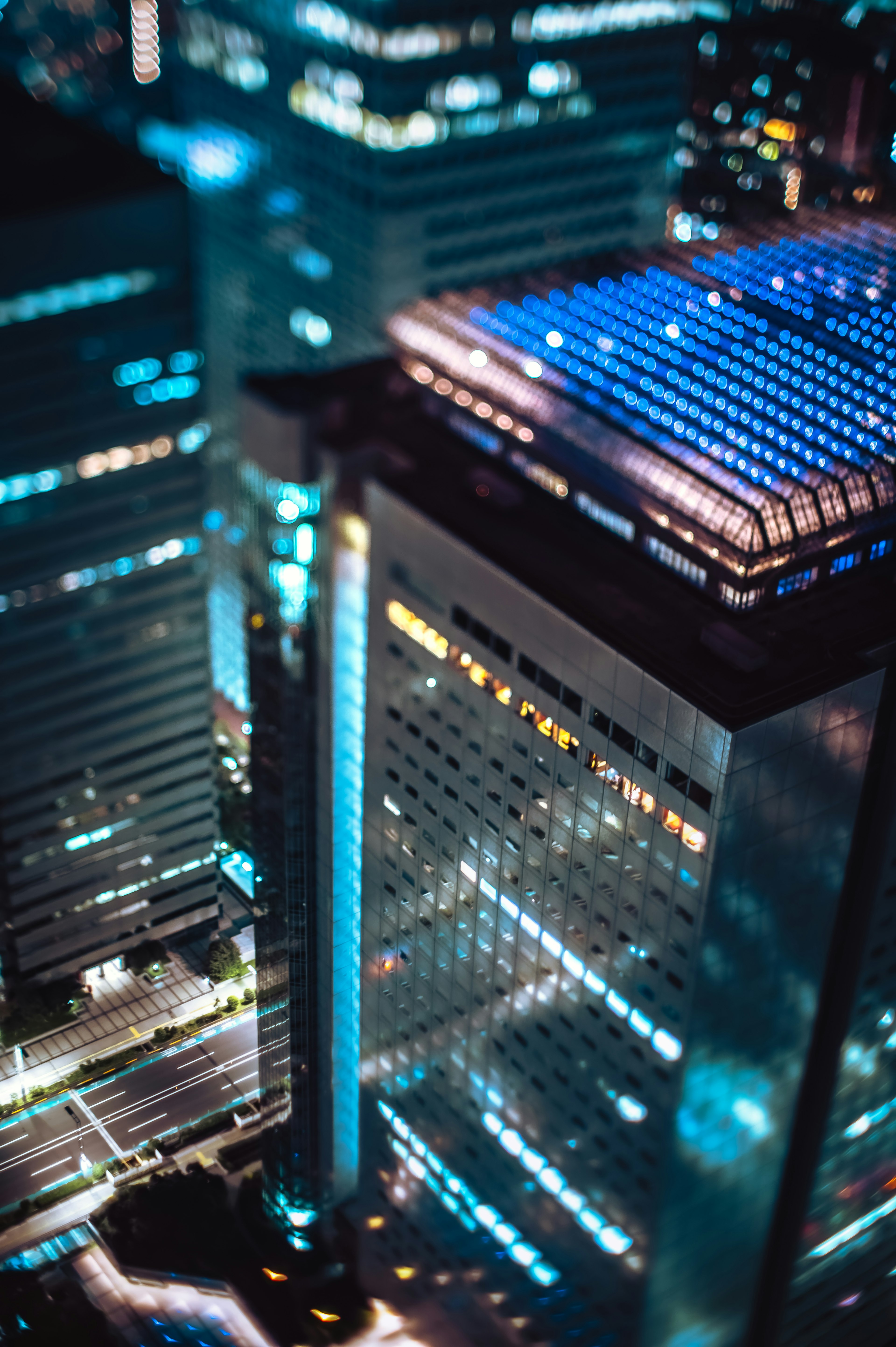 Vue aérienne de gratte-ciels urbains la nuit avec des lumières bleues et blanches saisissantes