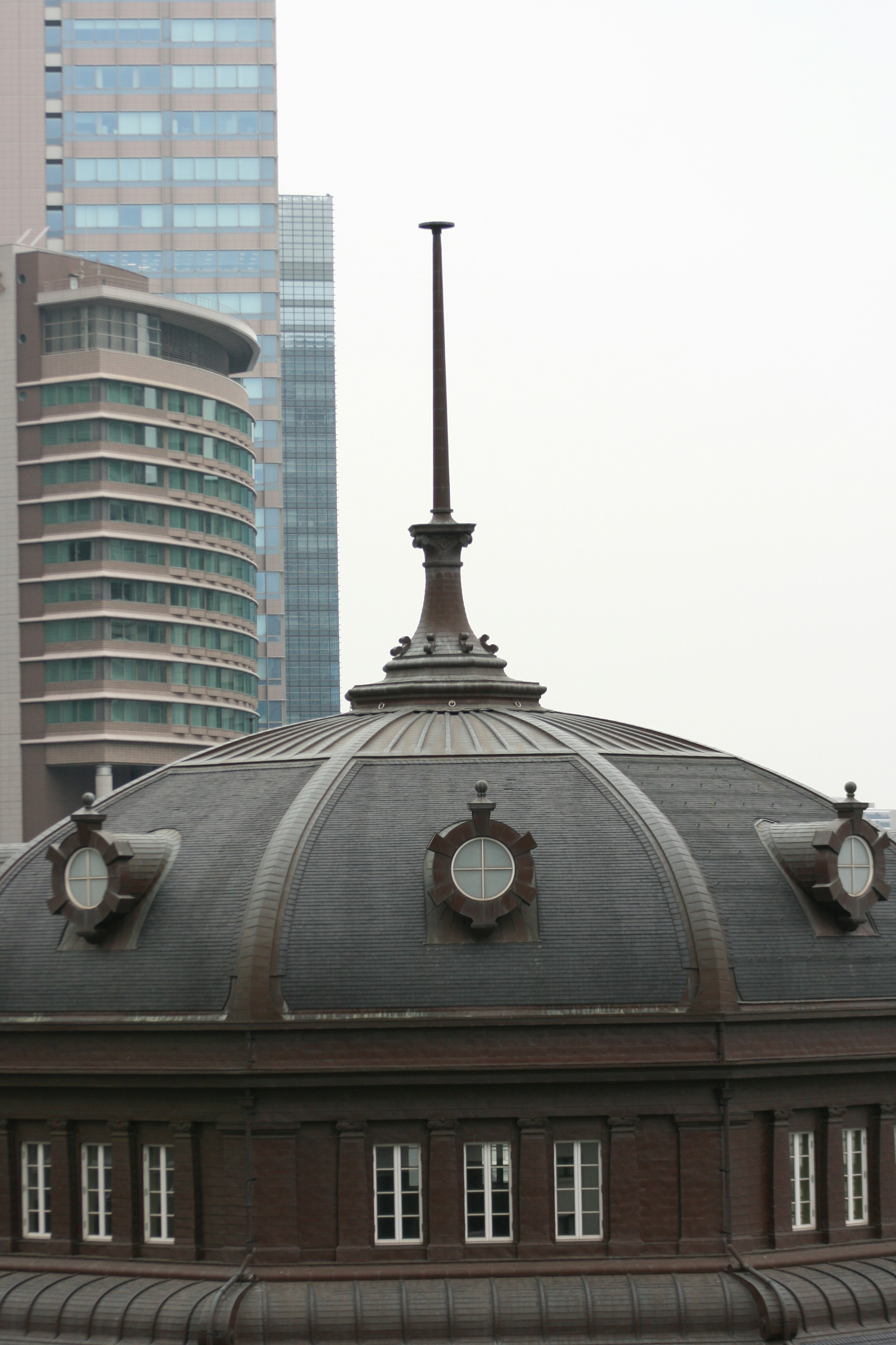 Kontras antara gedung pencakar langit modern dan atap kubah klasik