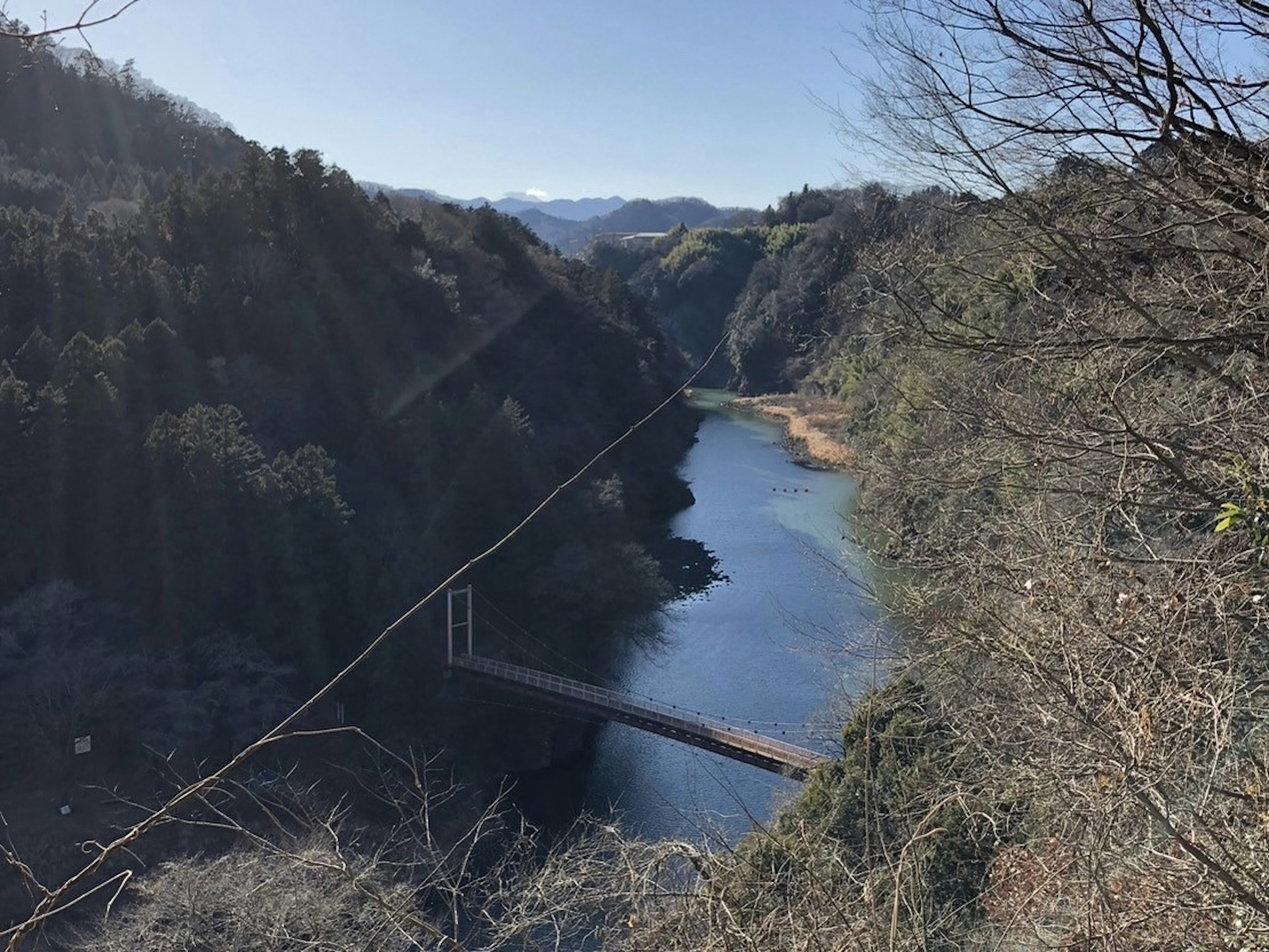 美しい山の景色と静かな川が流れ橋が架かっている