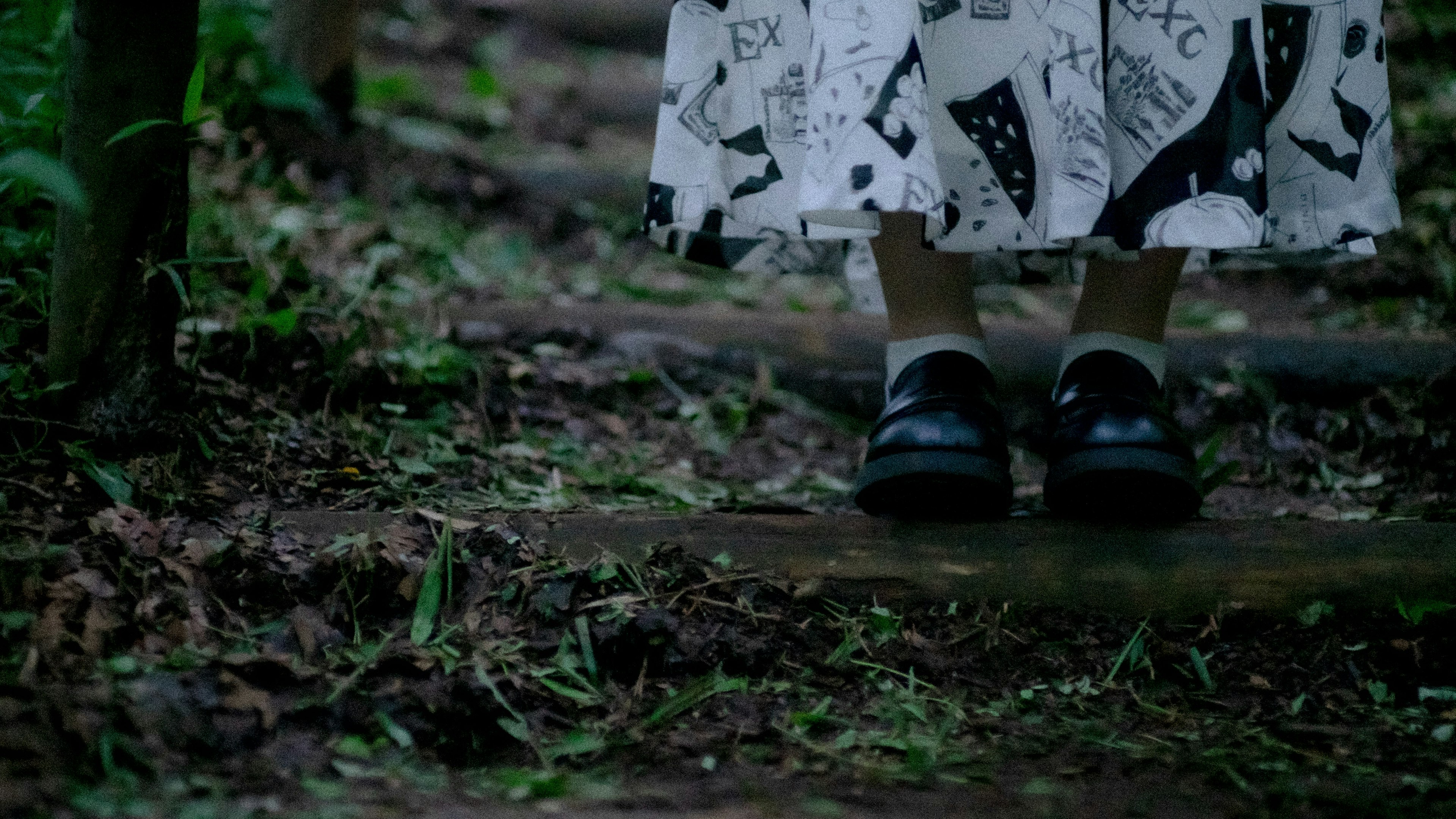 Pieds en chaussures noires portant une jupe blanche descendant des marches en bois