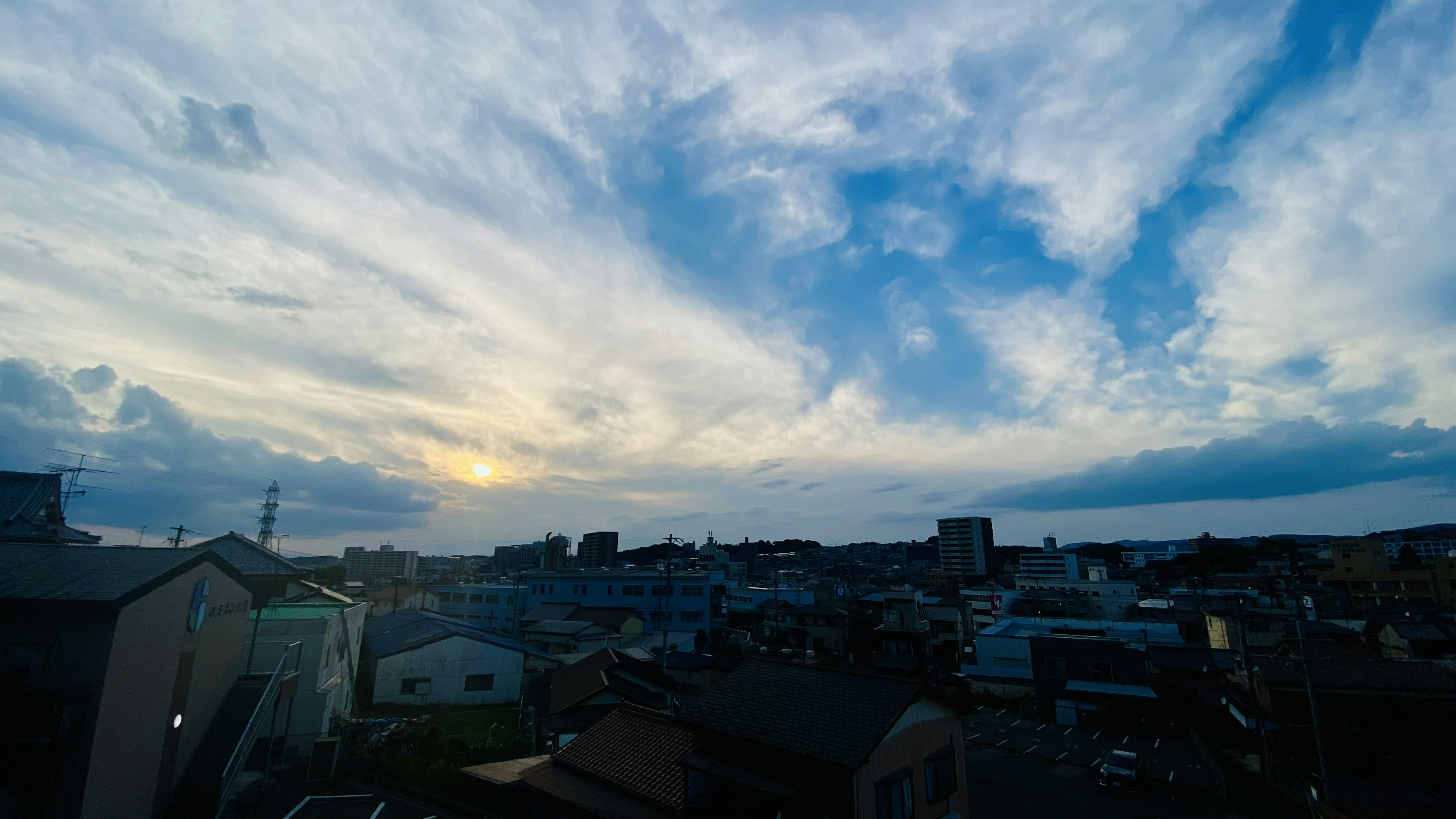 青空と雲が広がる風景 住宅街の上に沈む夕日