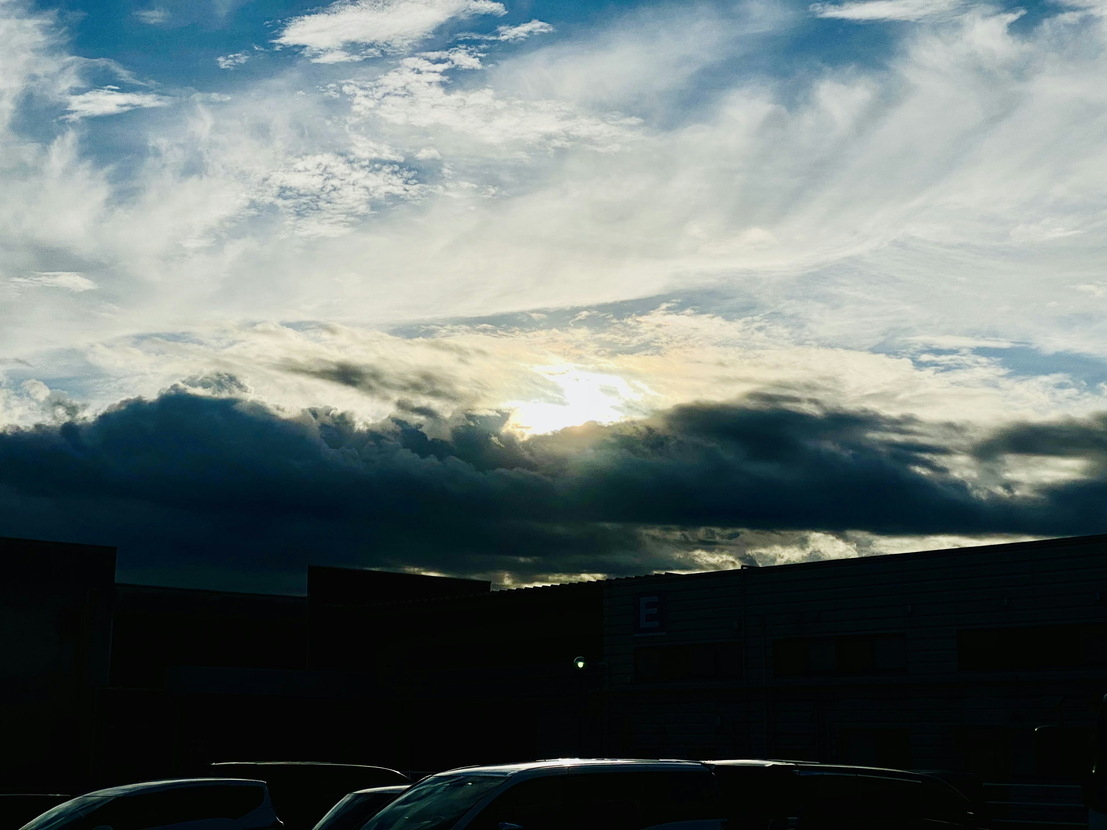 A view of sunlight breaking through clouds in a partly cloudy sky