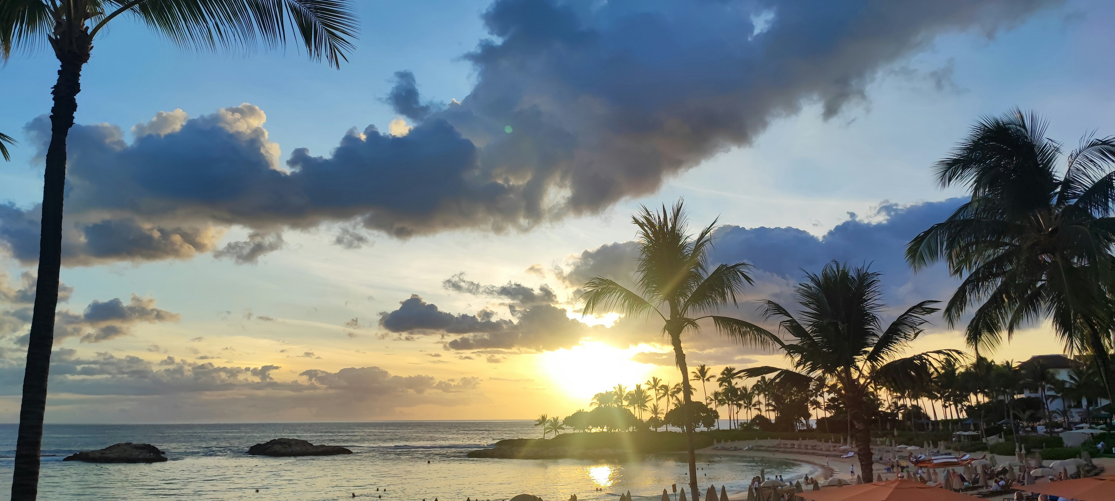 Vista escénica del atardecer sobre el océano con palmeras