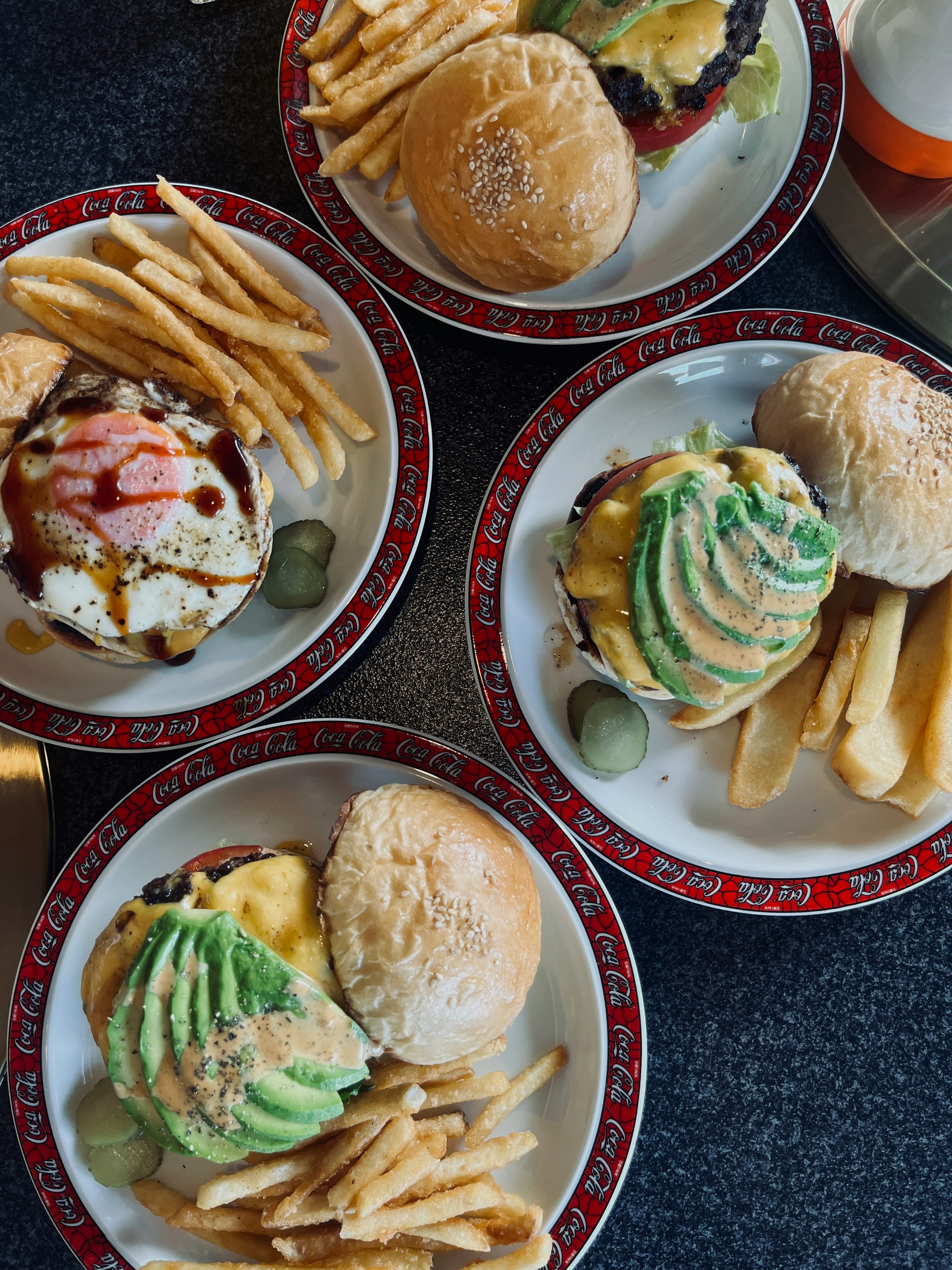 Four plates featuring delicious burgers and fries