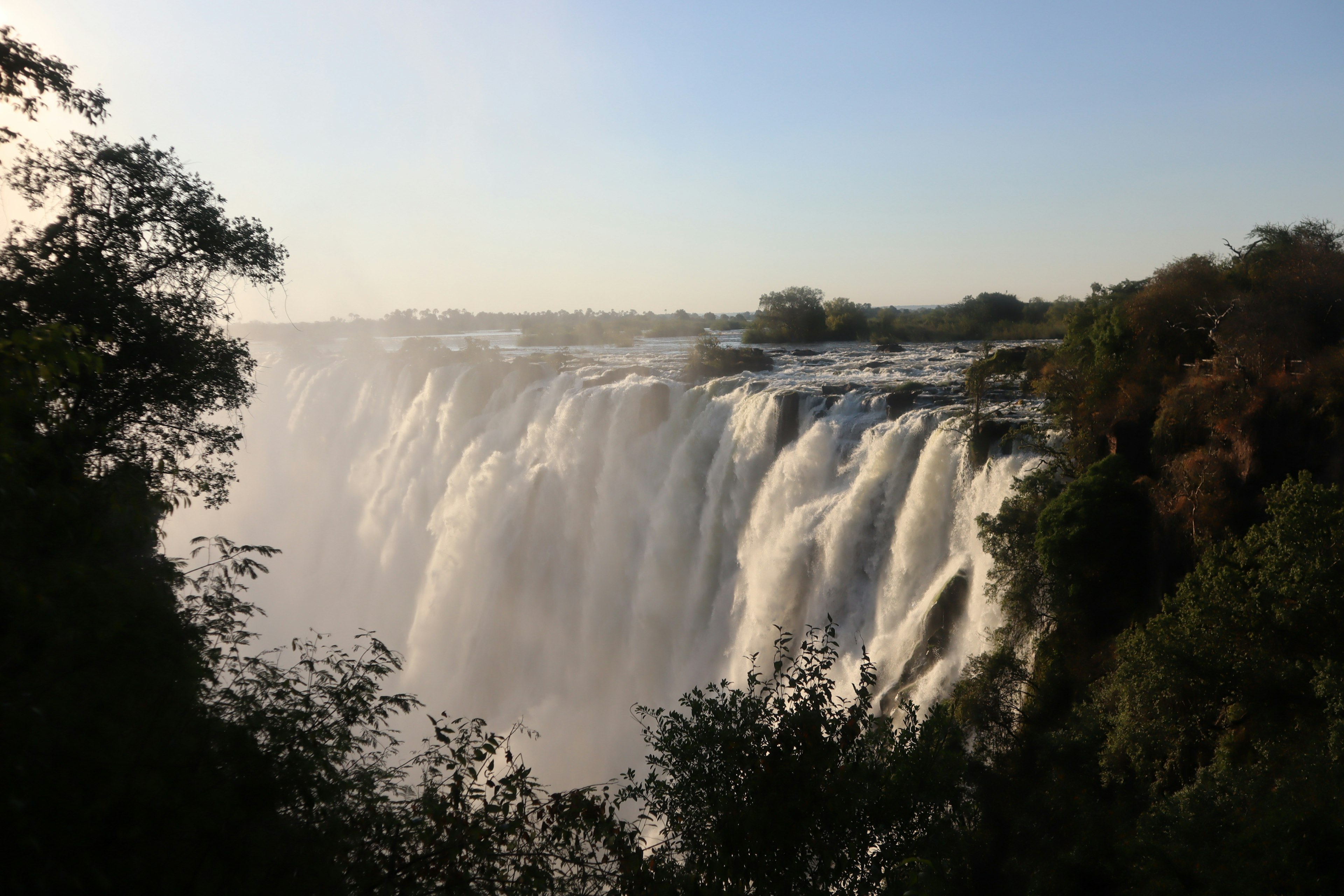 Cảnh quan hùng vĩ của thác Iguazu với dòng nước chảy và ánh sáng mặt trời chiếu sáng làn sương mù