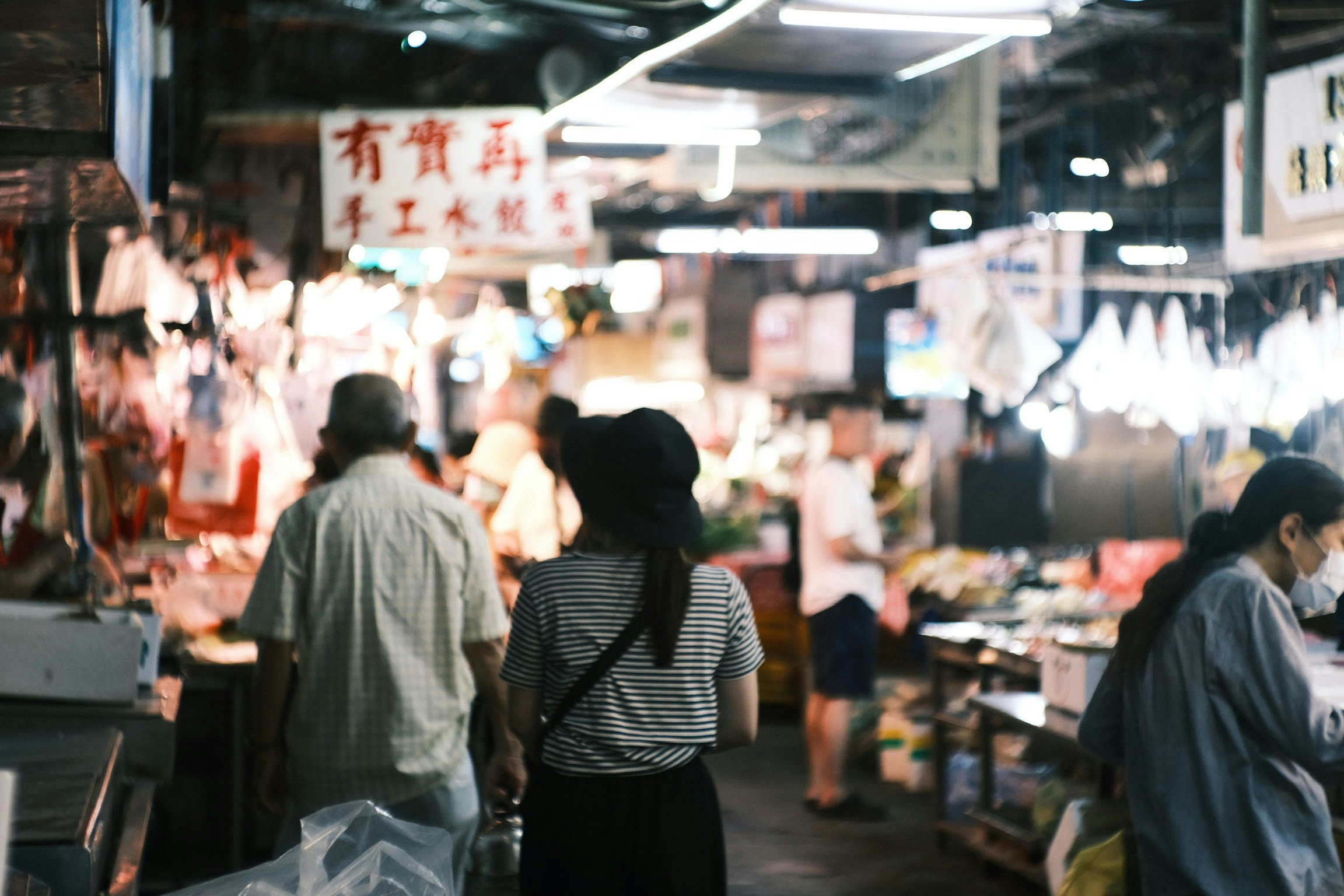 熱鬧的市場場景,有人走動和各種攤位