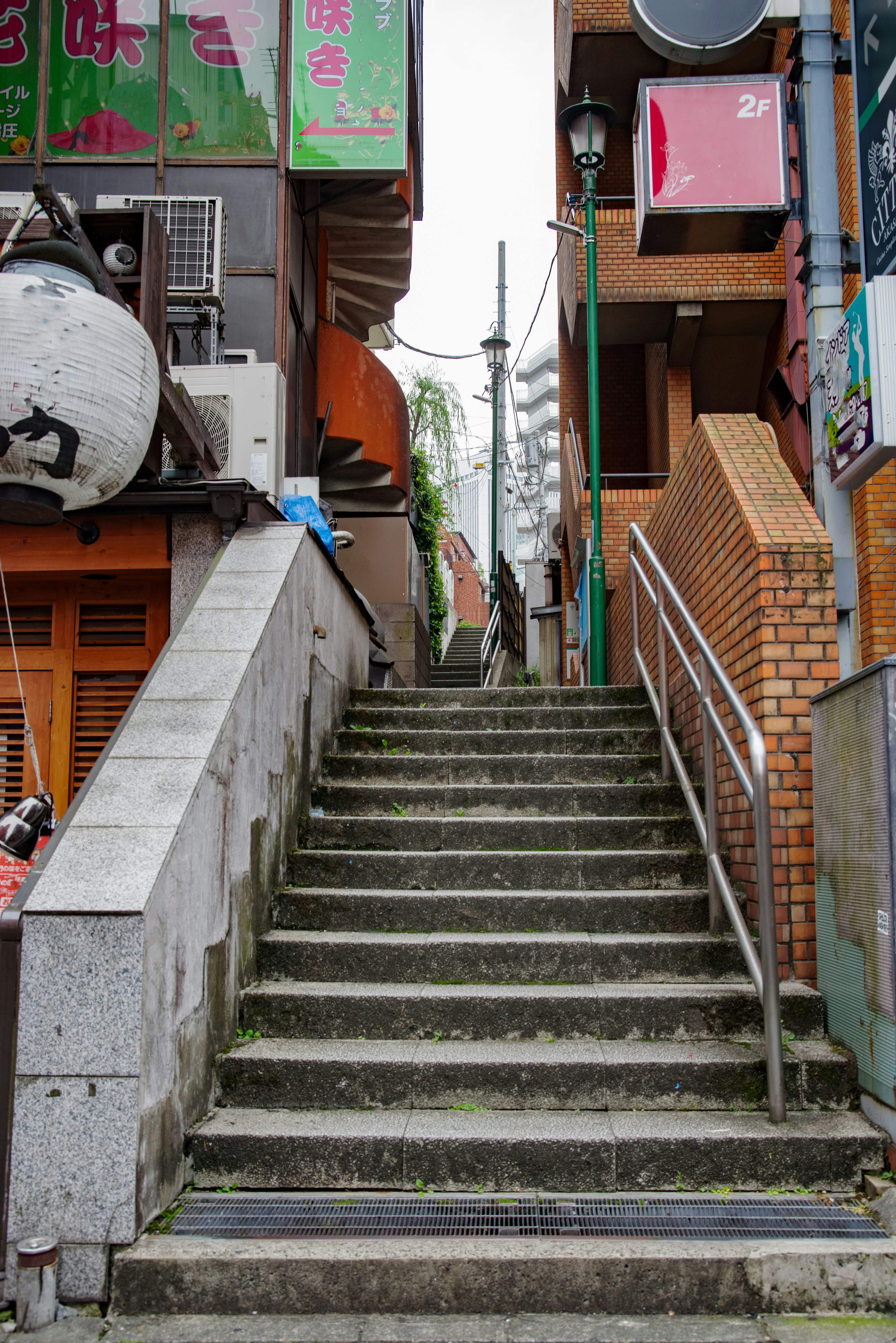 Escalier montant avec des panneaux colorés et des bâtiments urbains