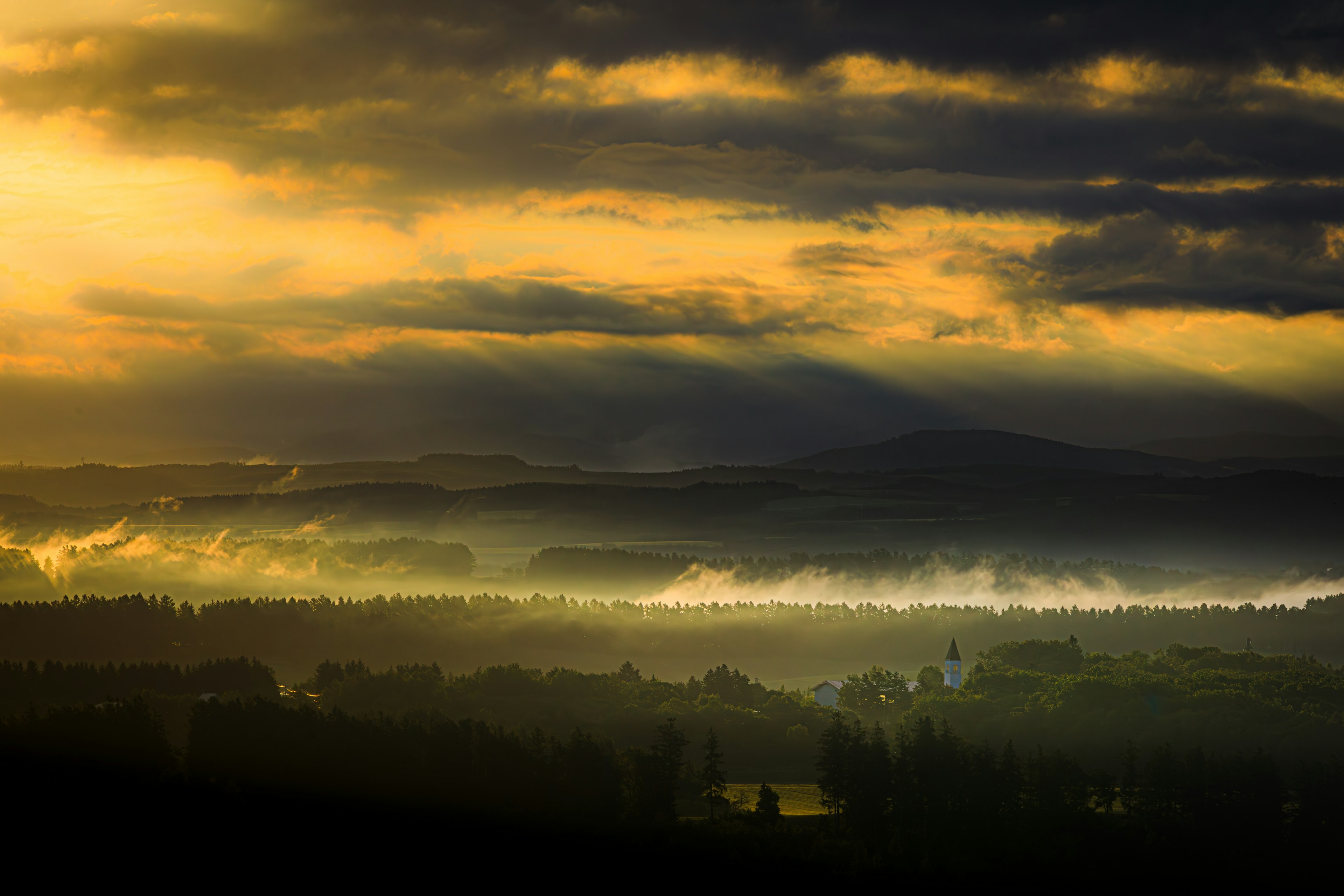 Paisaje impresionante con niebla y luz dramática del atardecer