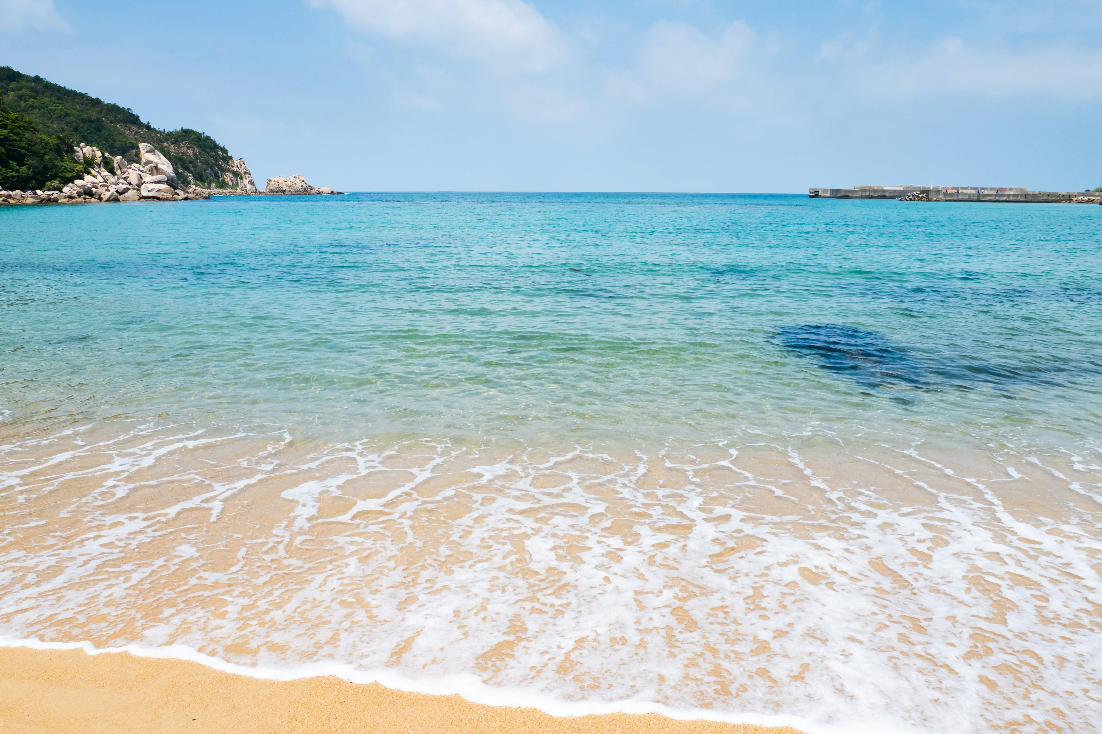 ชายหาดที่มีทิวทัศน์สวยงามน้ำทะเลใสและคลื่นอ่อน