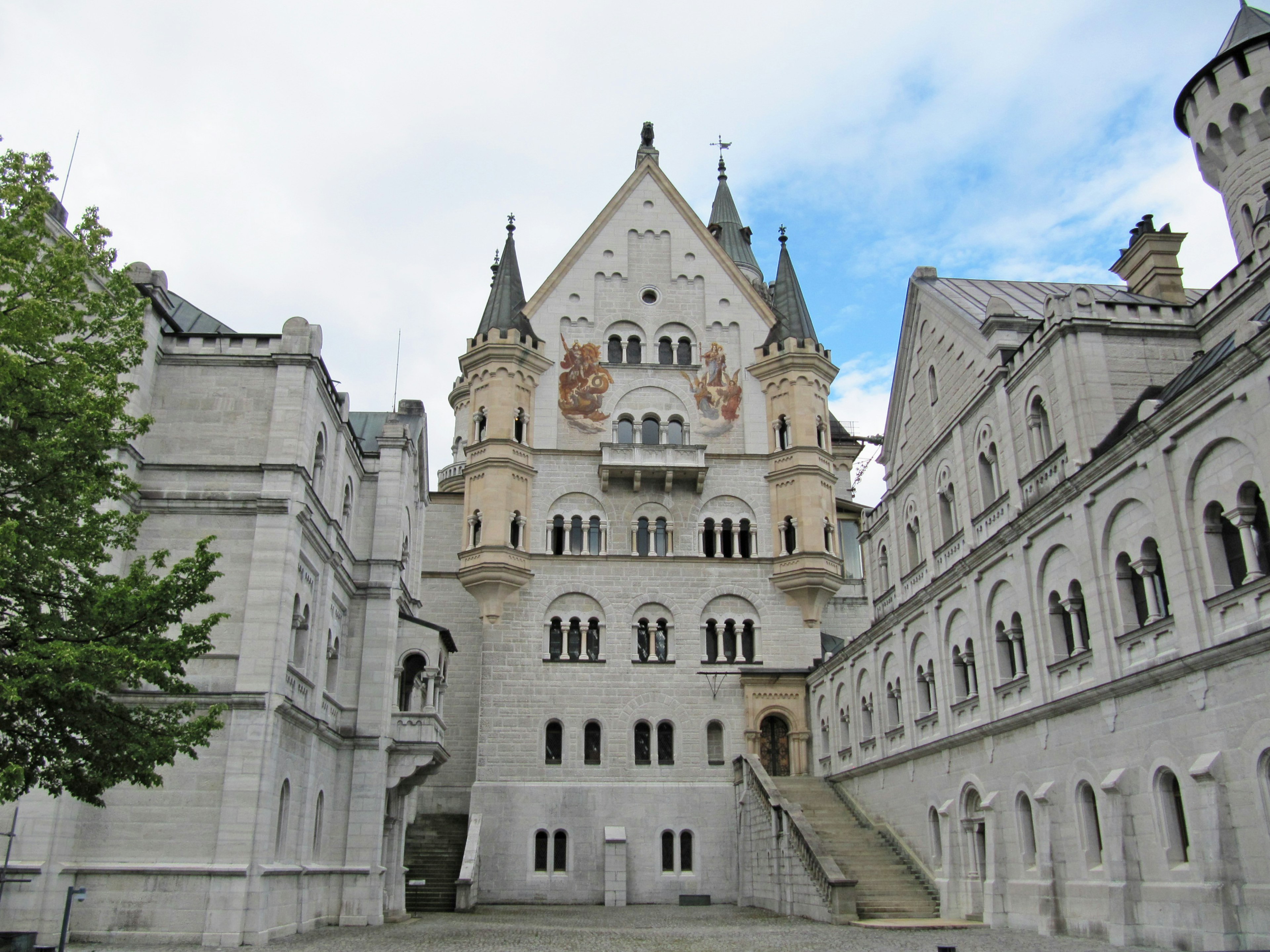 Pemandangan menakjubkan dari Kastil Neuschwanstein dengan arsitektur rinci dan vegetasi di sekitarnya