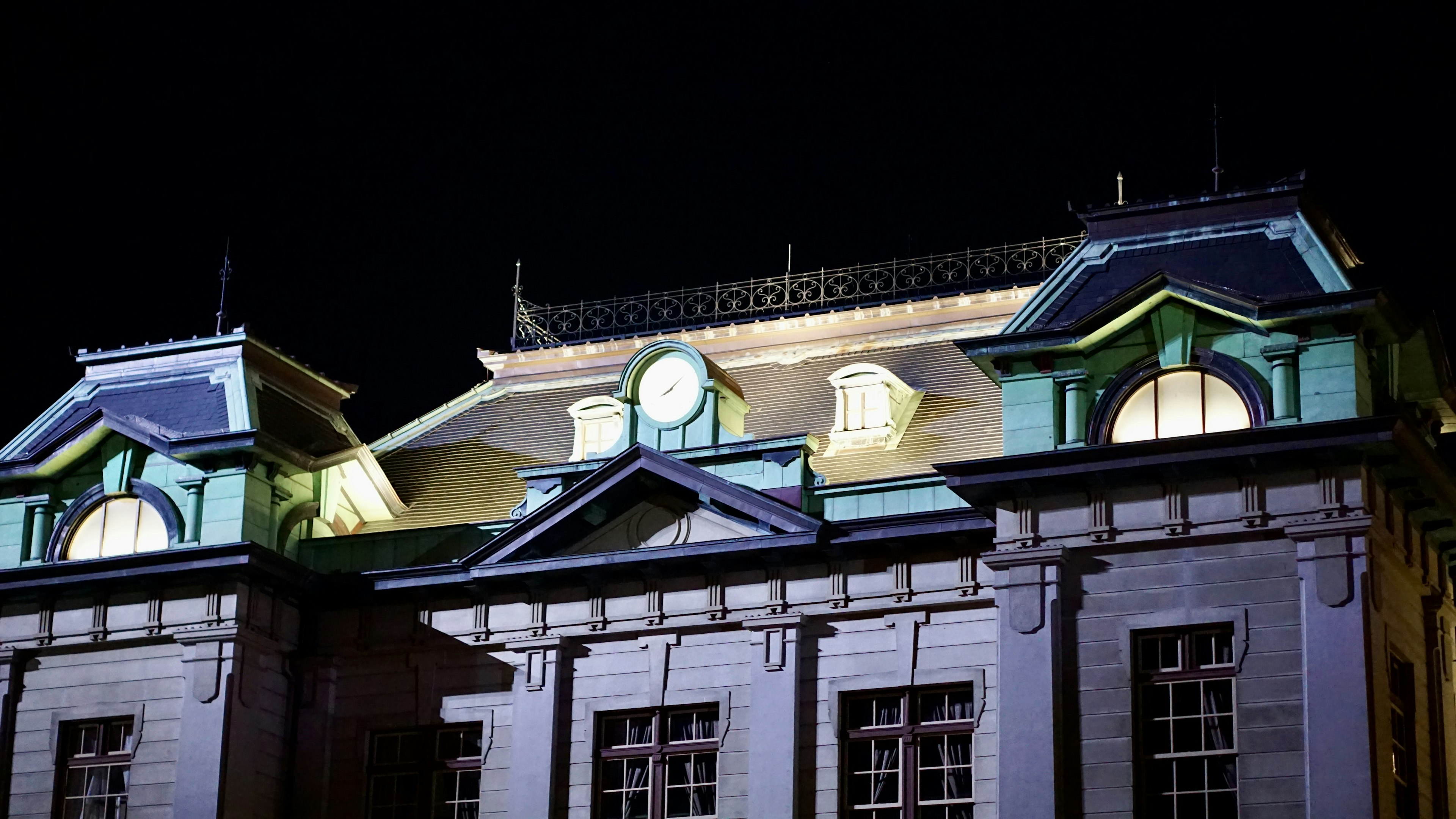 Vista detallada del techo de un edificio histórico iluminado por la noche