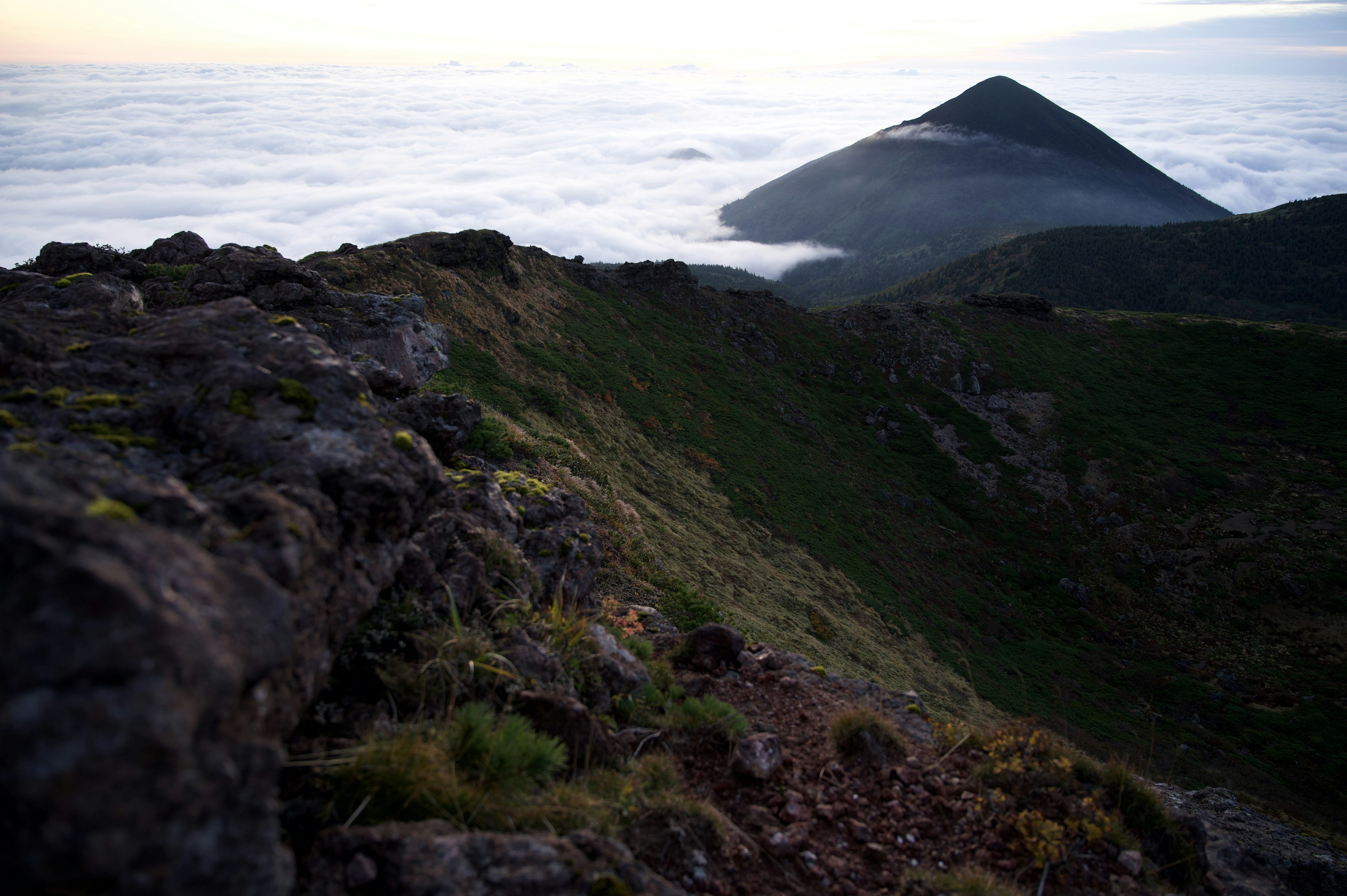 Paysage montagneux au-dessus d'une mer de nuages avec terrain rocheux