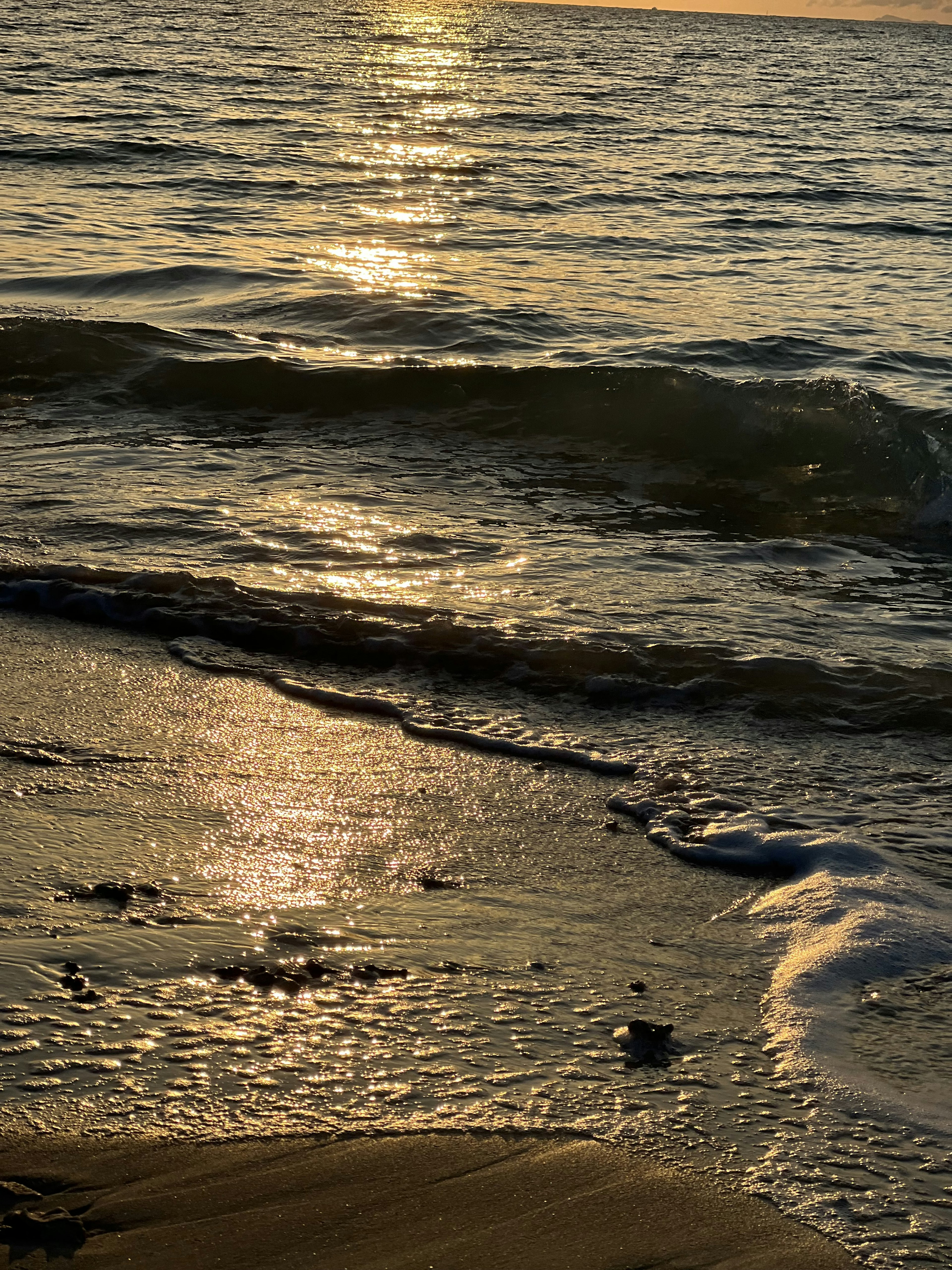 Bella scena di onde e riflesso del tramonto sulla spiaggia