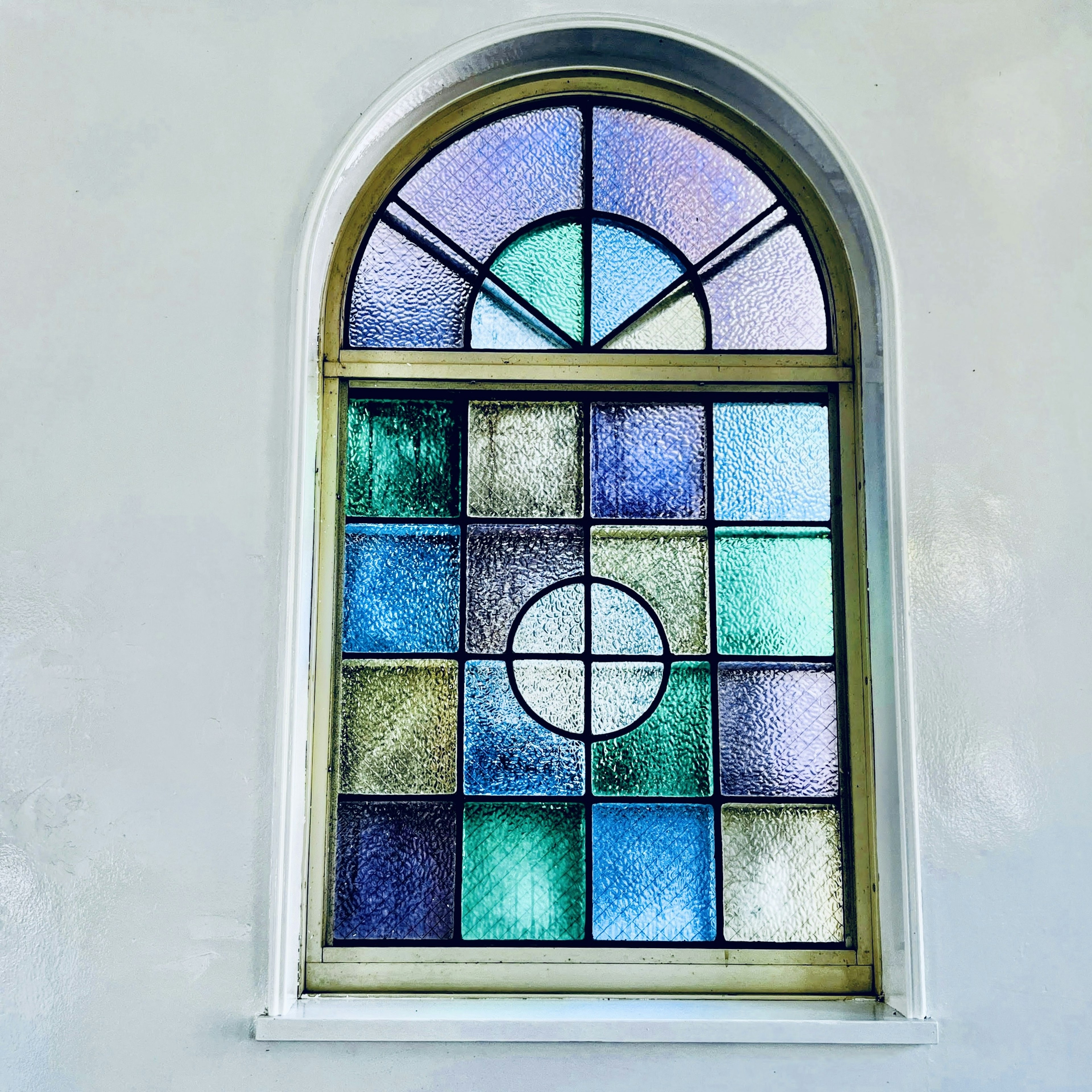 Arched stained glass window vibrant colors and geometric patterns