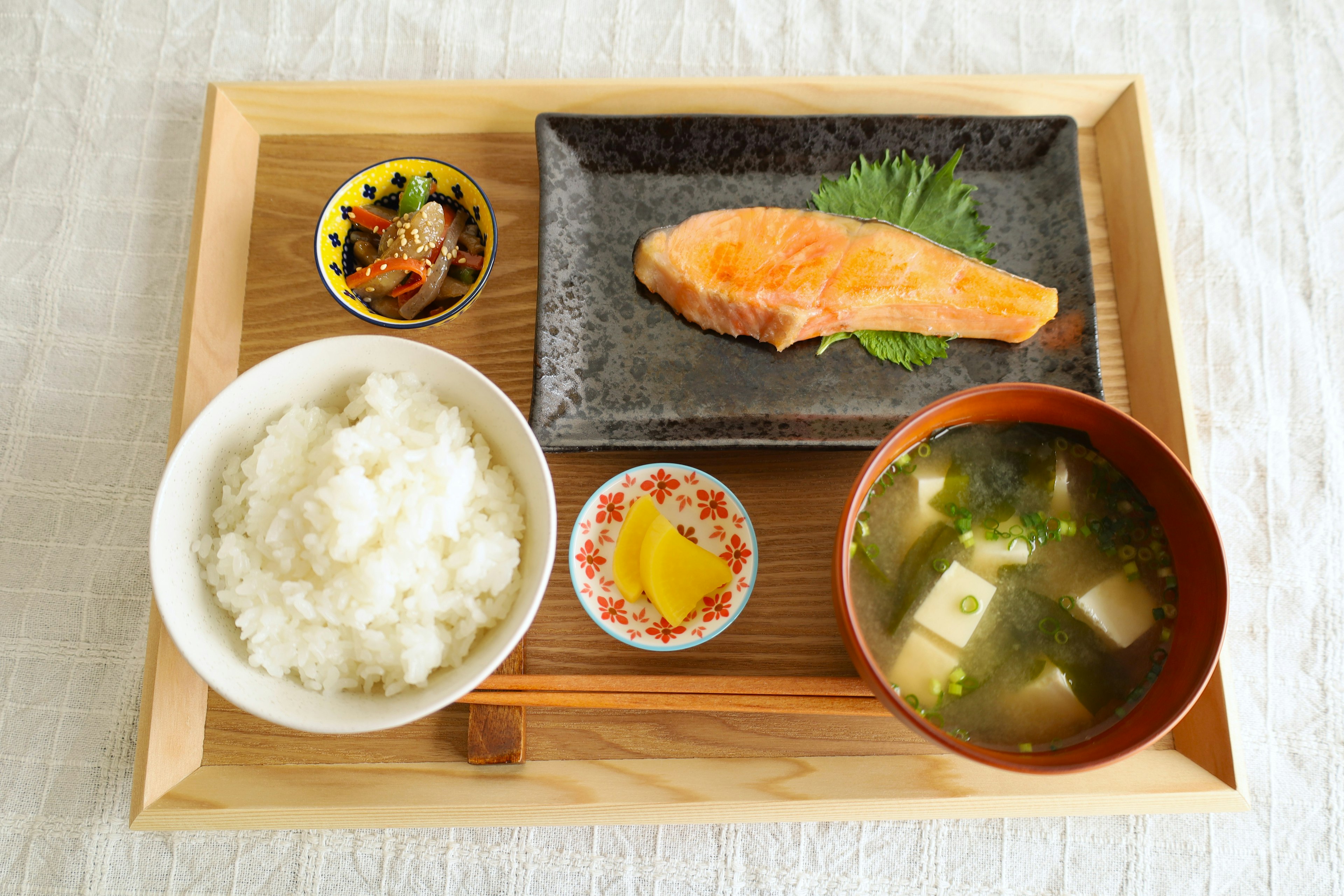 日本餐包含三文鱼片米饭味噌汤和配菜