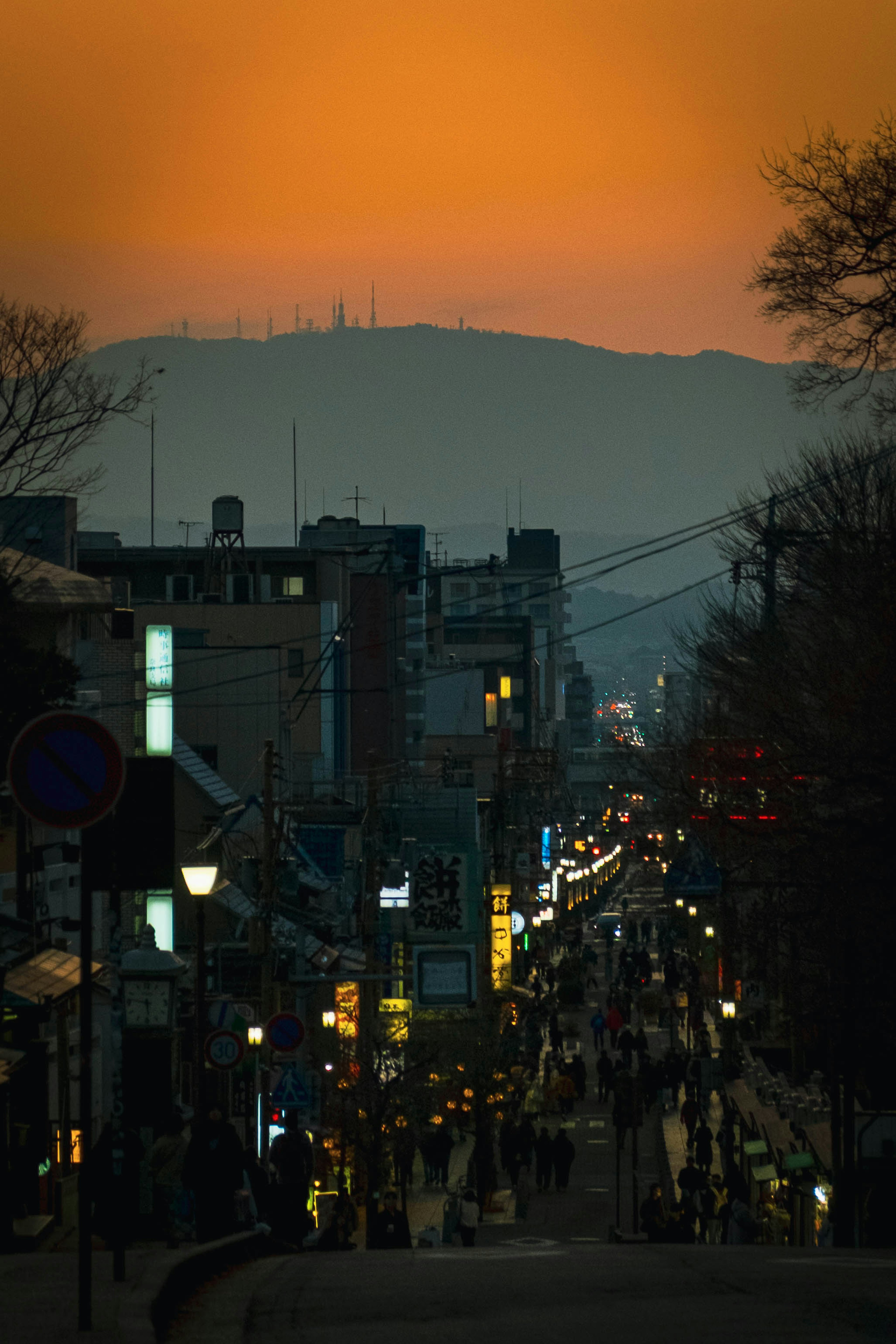 Stadtlandschaft bei Sonnenuntergang mit Menschen auf der Straße