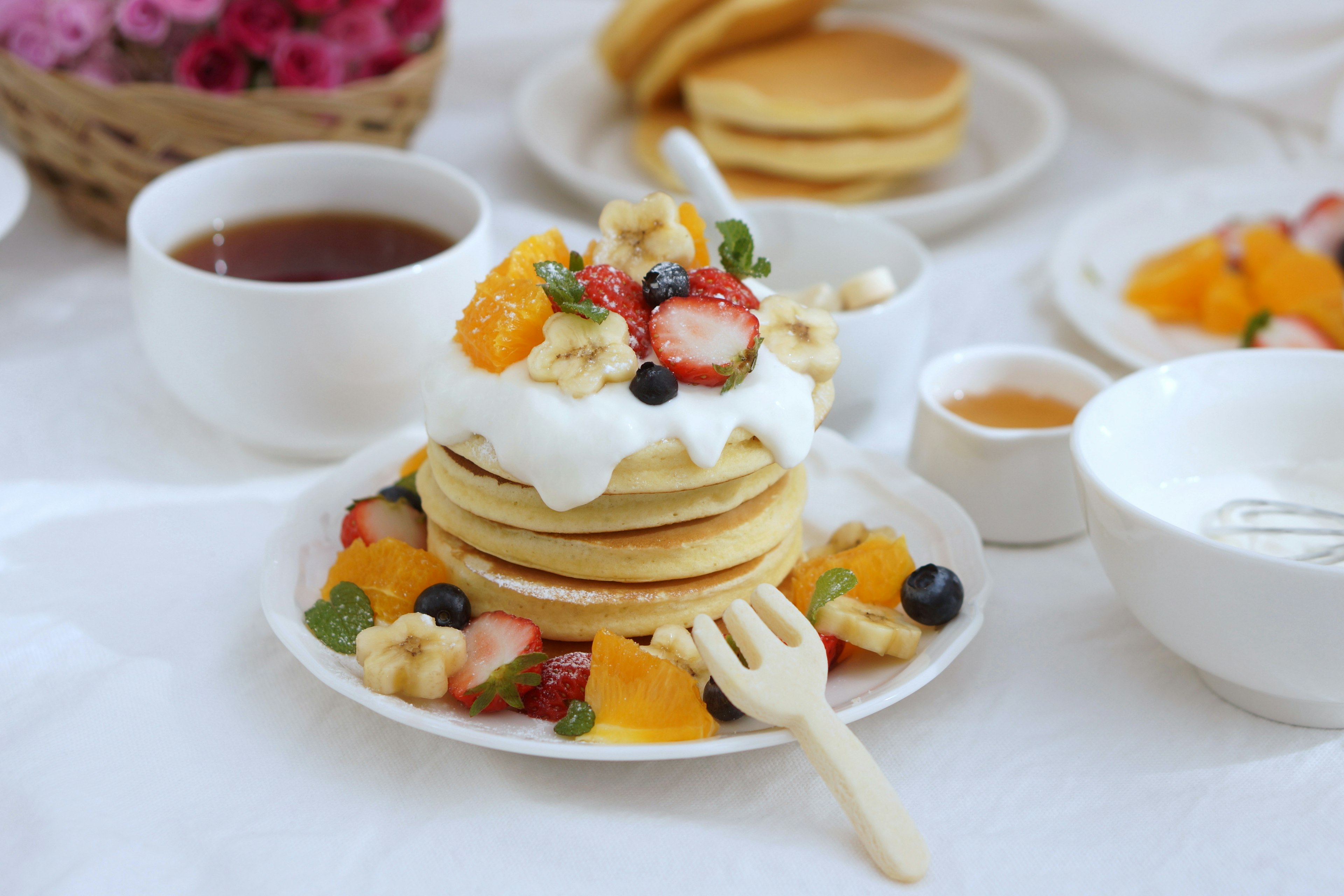 Fluffige Pfannkuchen mit Obst und Schlagsahne zum Frühstück