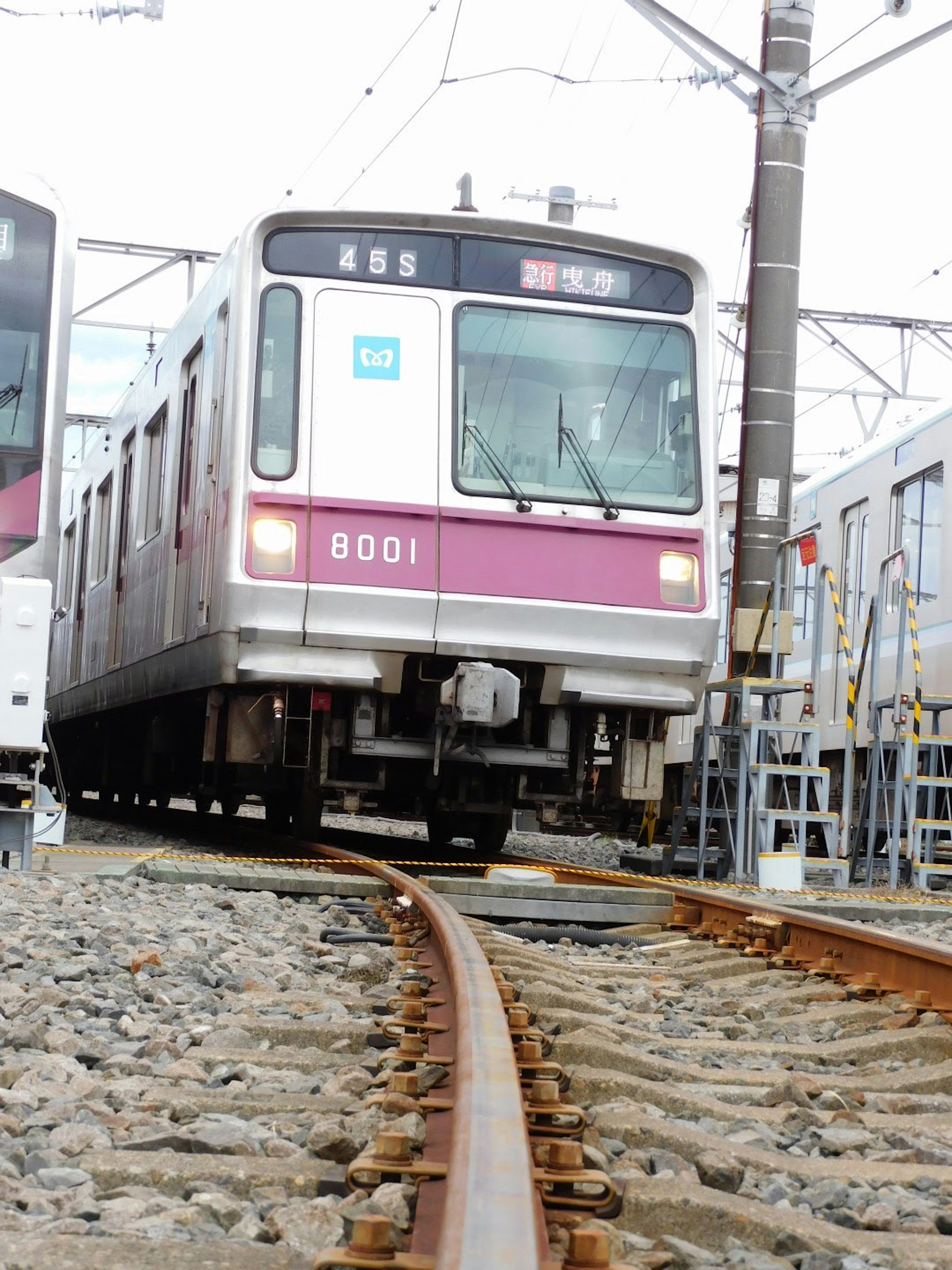 Foreground of a train running along the tracks near a railway station