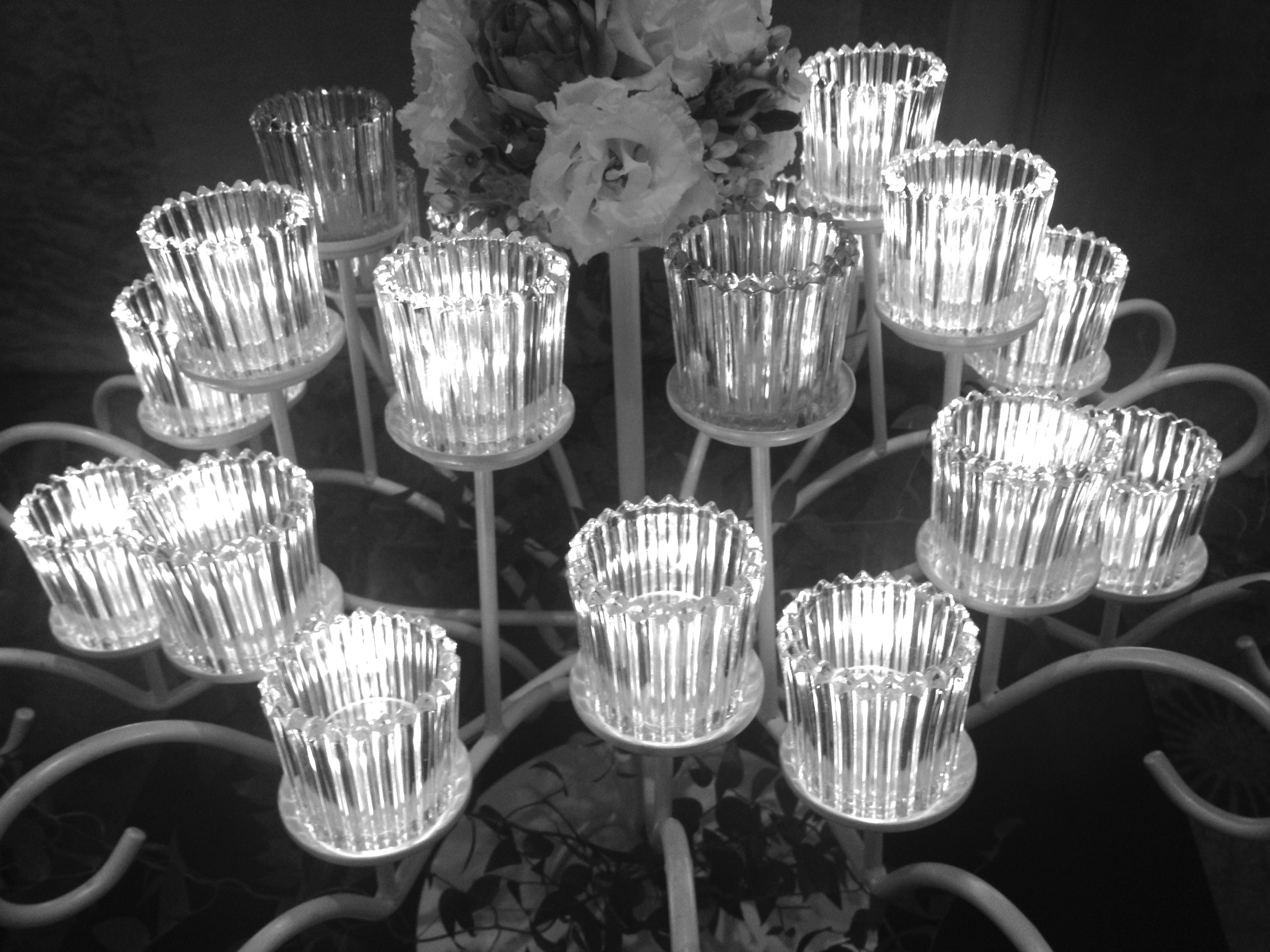 Illuminated transparent candle holders arranged on a black and white chandelier