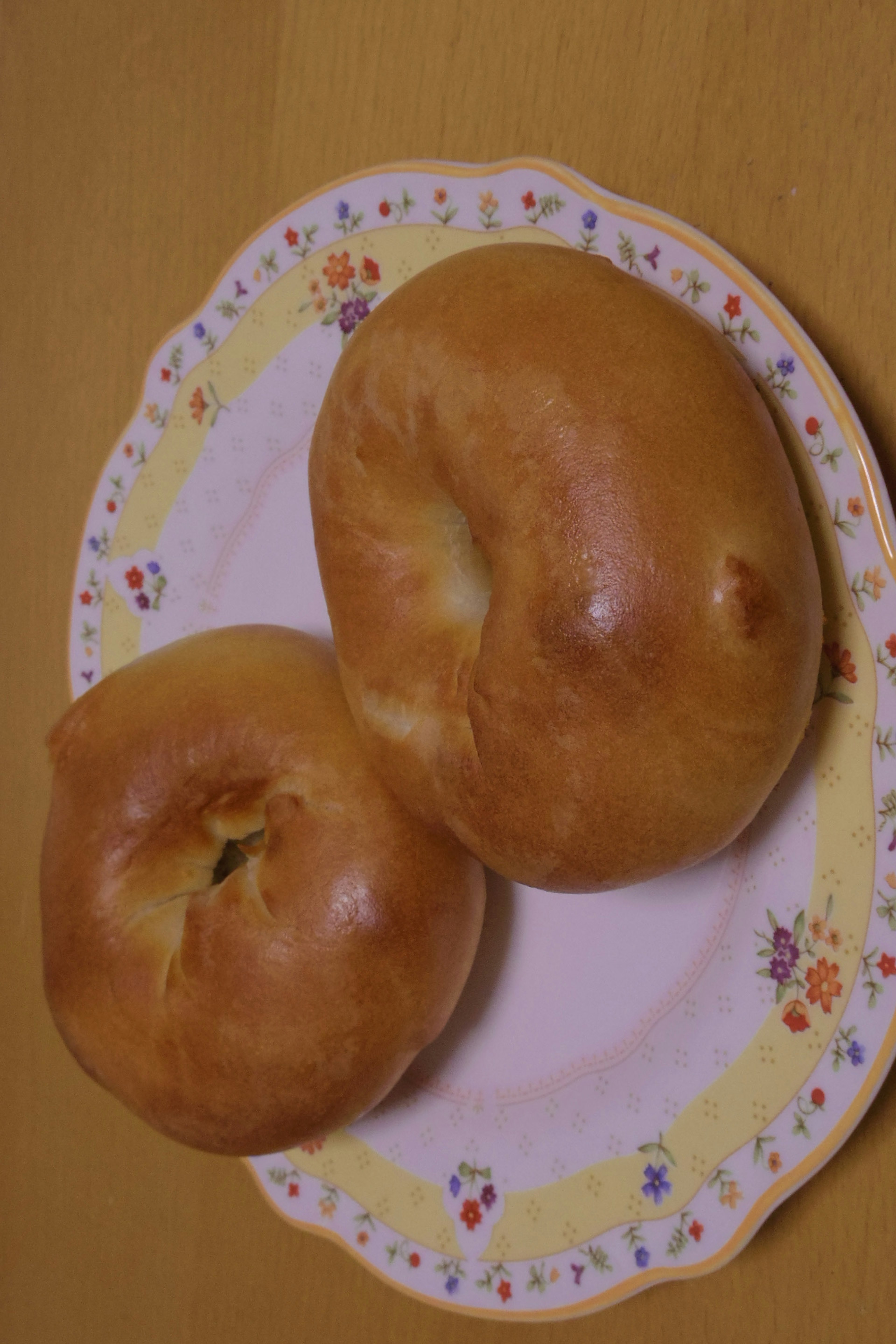 Two bagels displayed on a floral plate