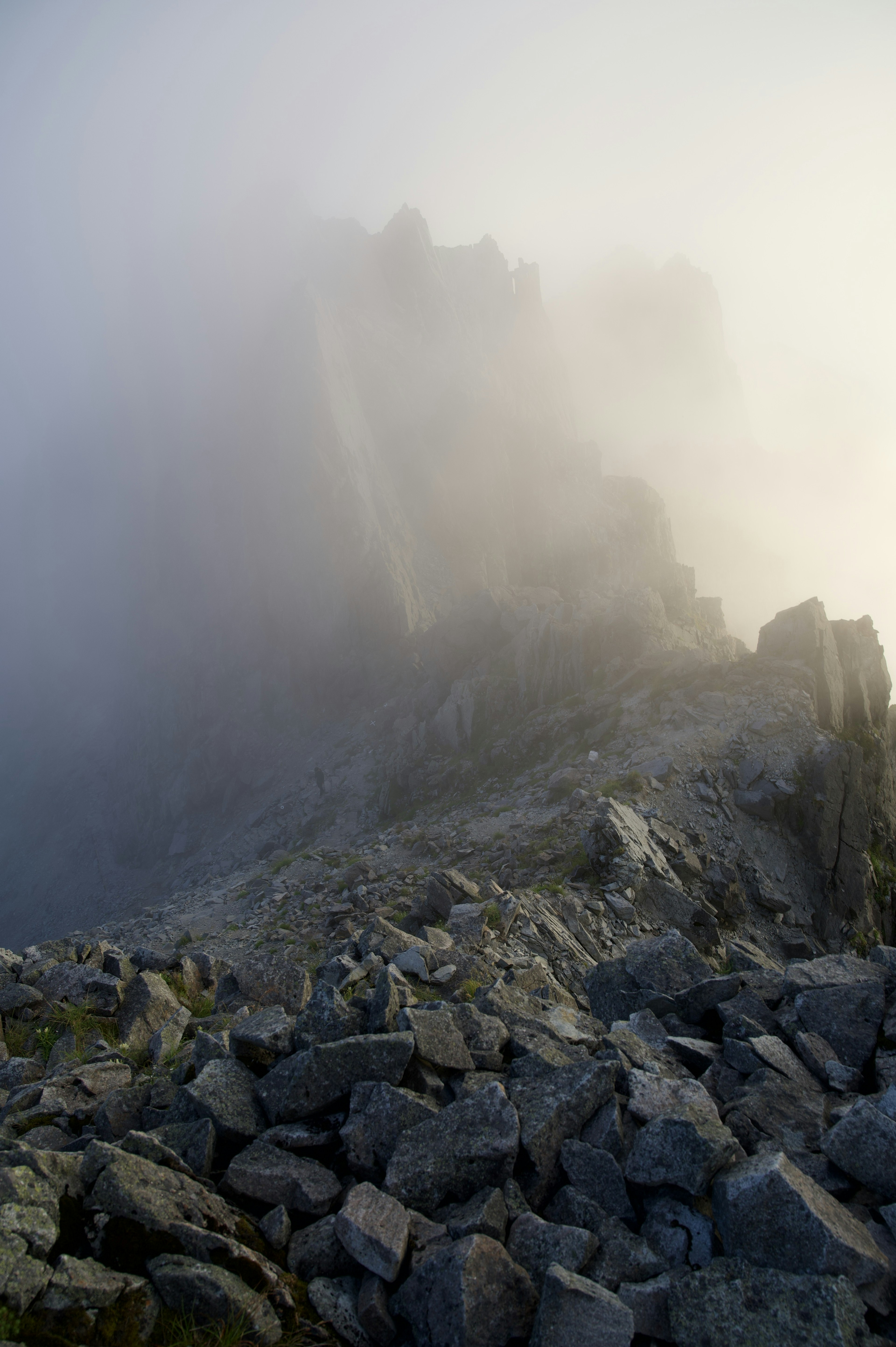 Paesaggio di scogliera rocciosa avvolto nella nebbia con sfondo indistinto