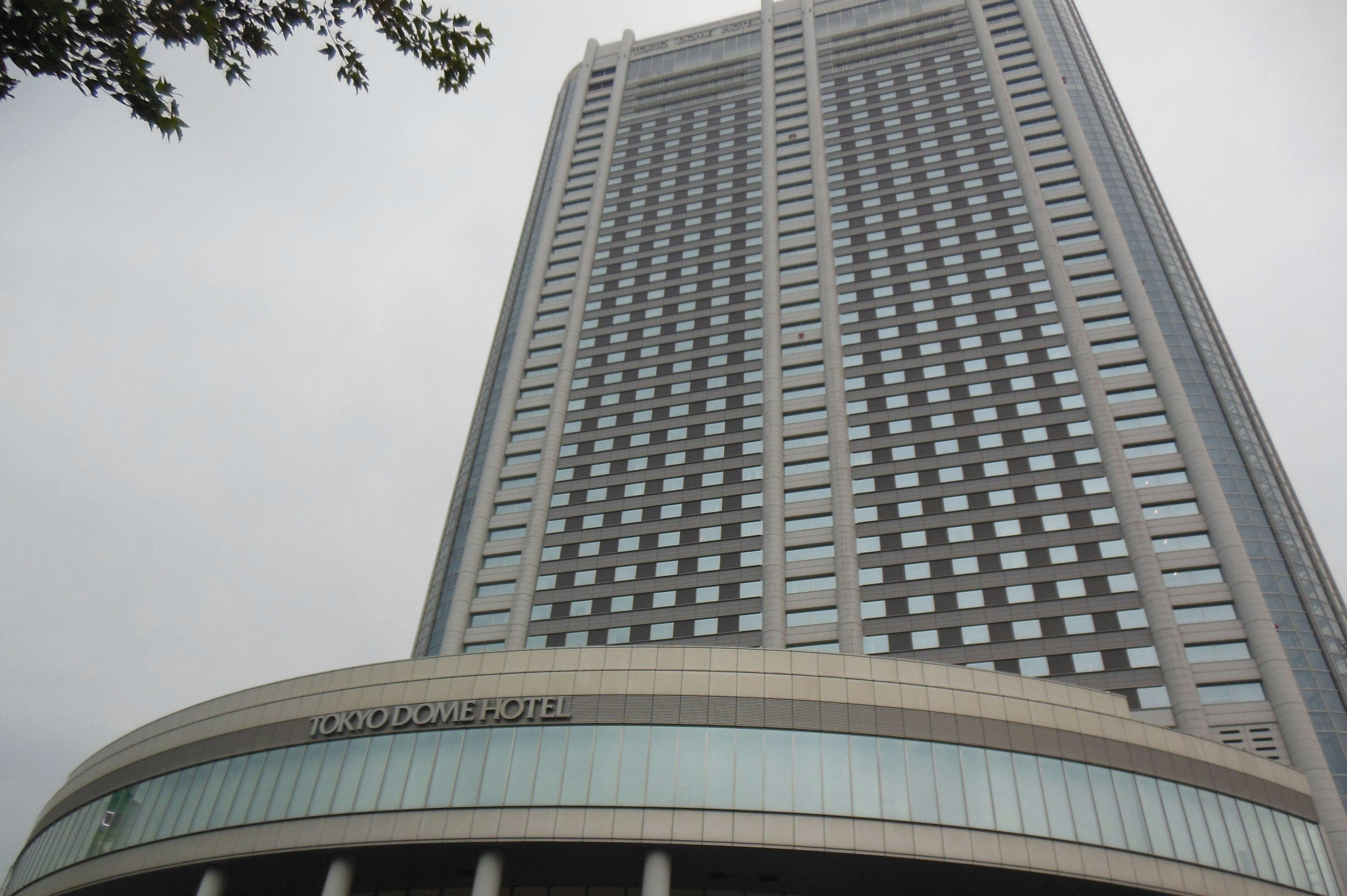 Gedung pencakar langit modern dengan fasad unik dan pintu masuk melengkung