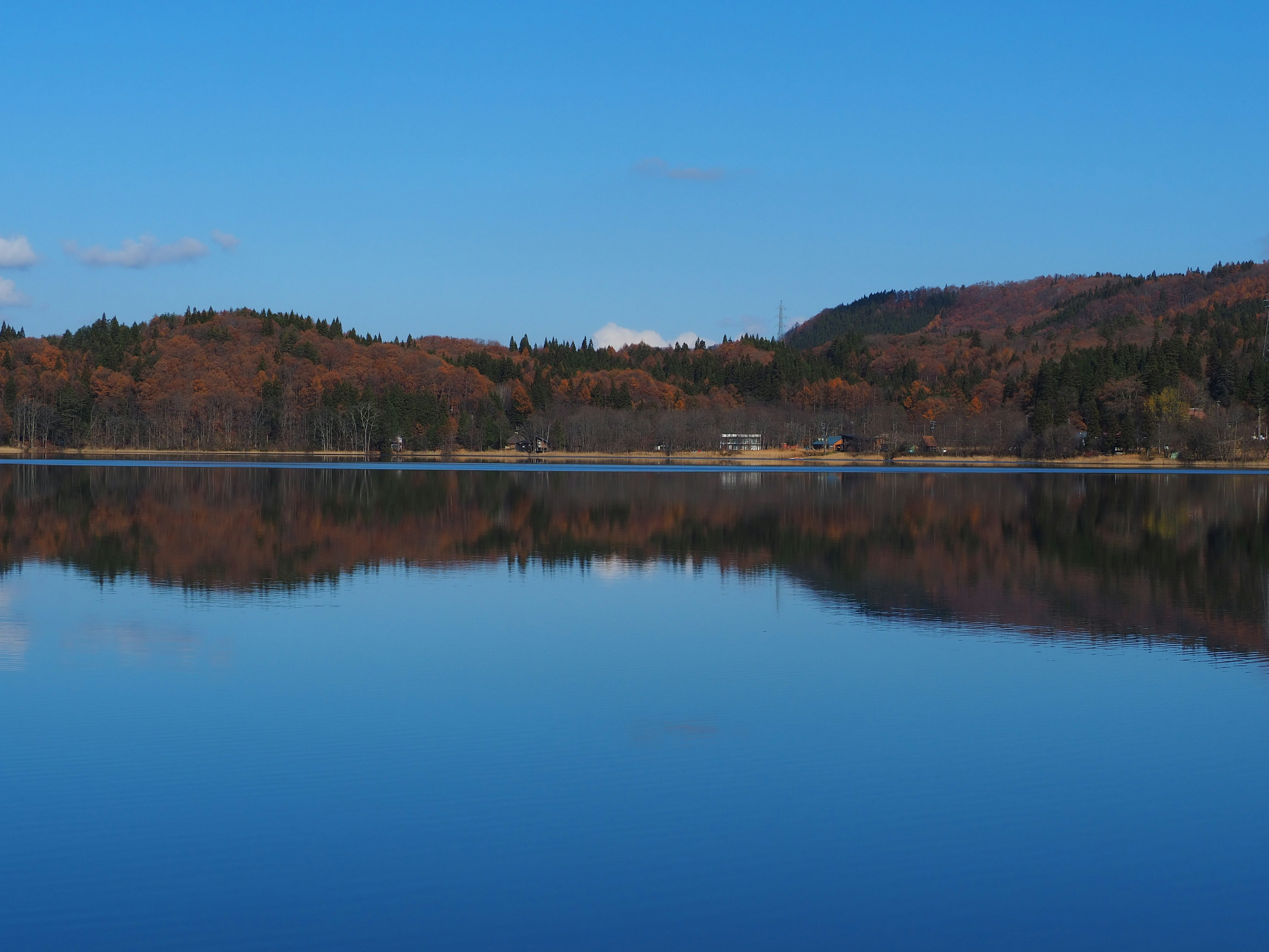 Ruhige Seenreflexion mit klarem blauen Himmel