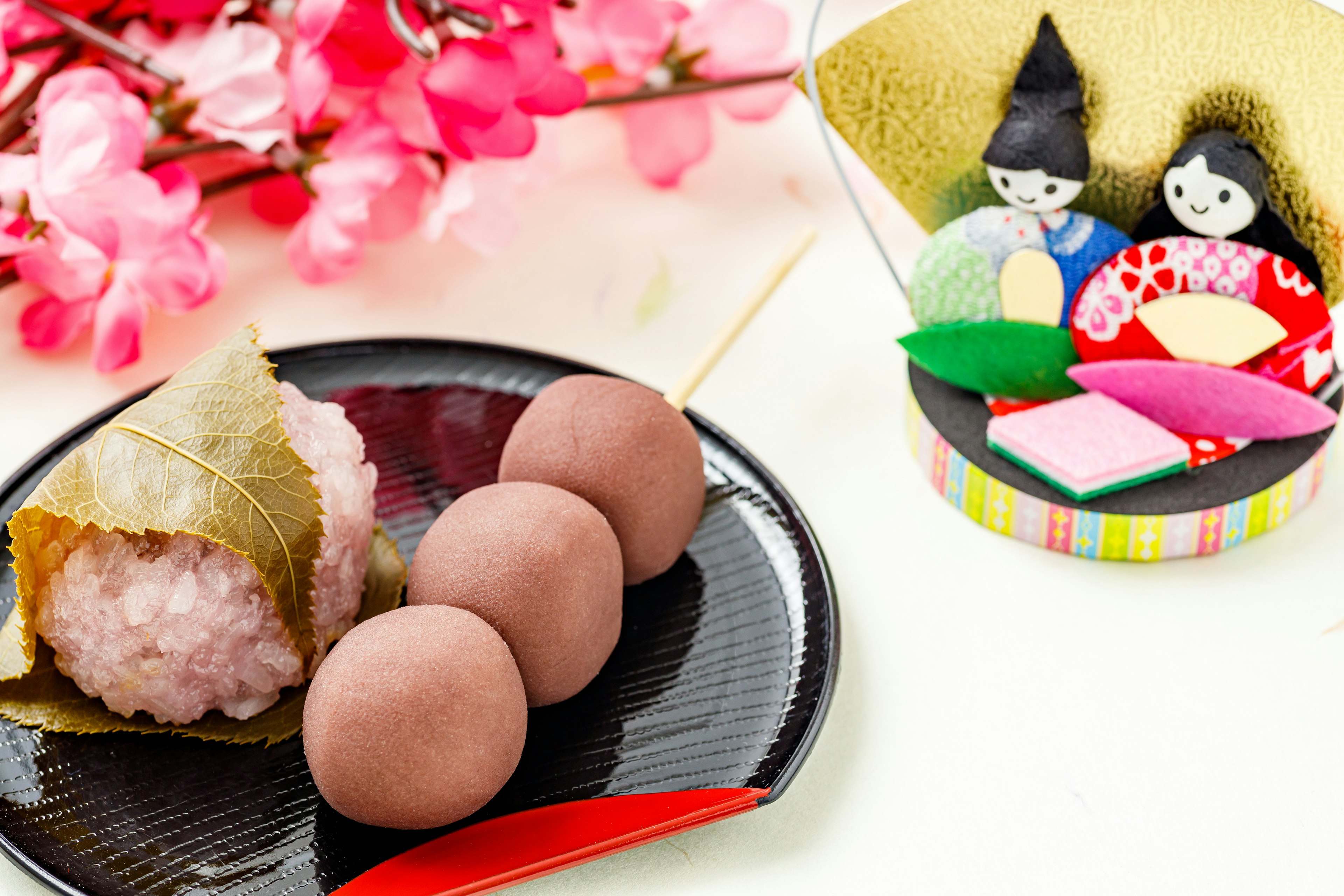 A display of traditional Japanese sweets with cherry blossoms and hina dolls