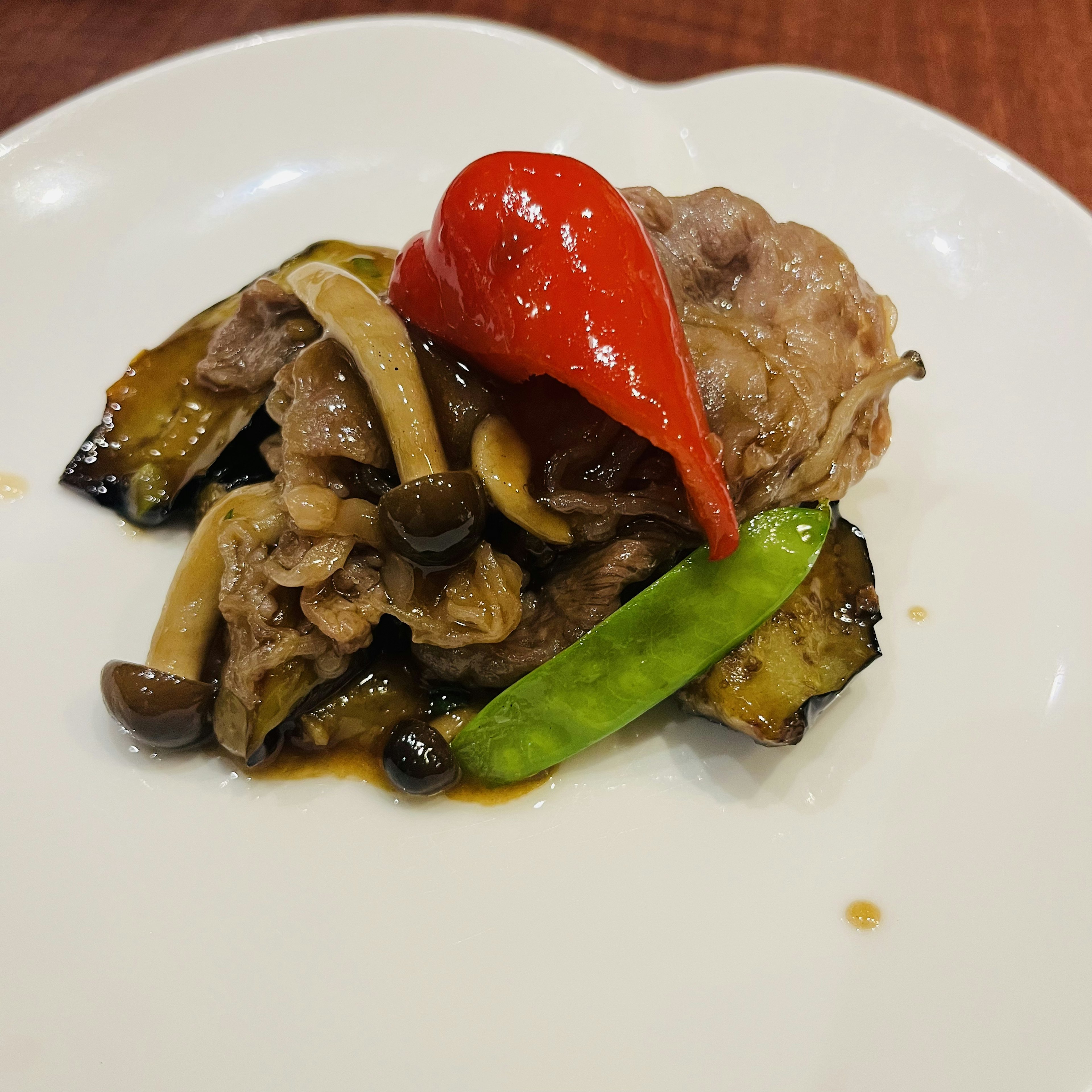 A colorful dish featuring meat and vegetables on a white plate