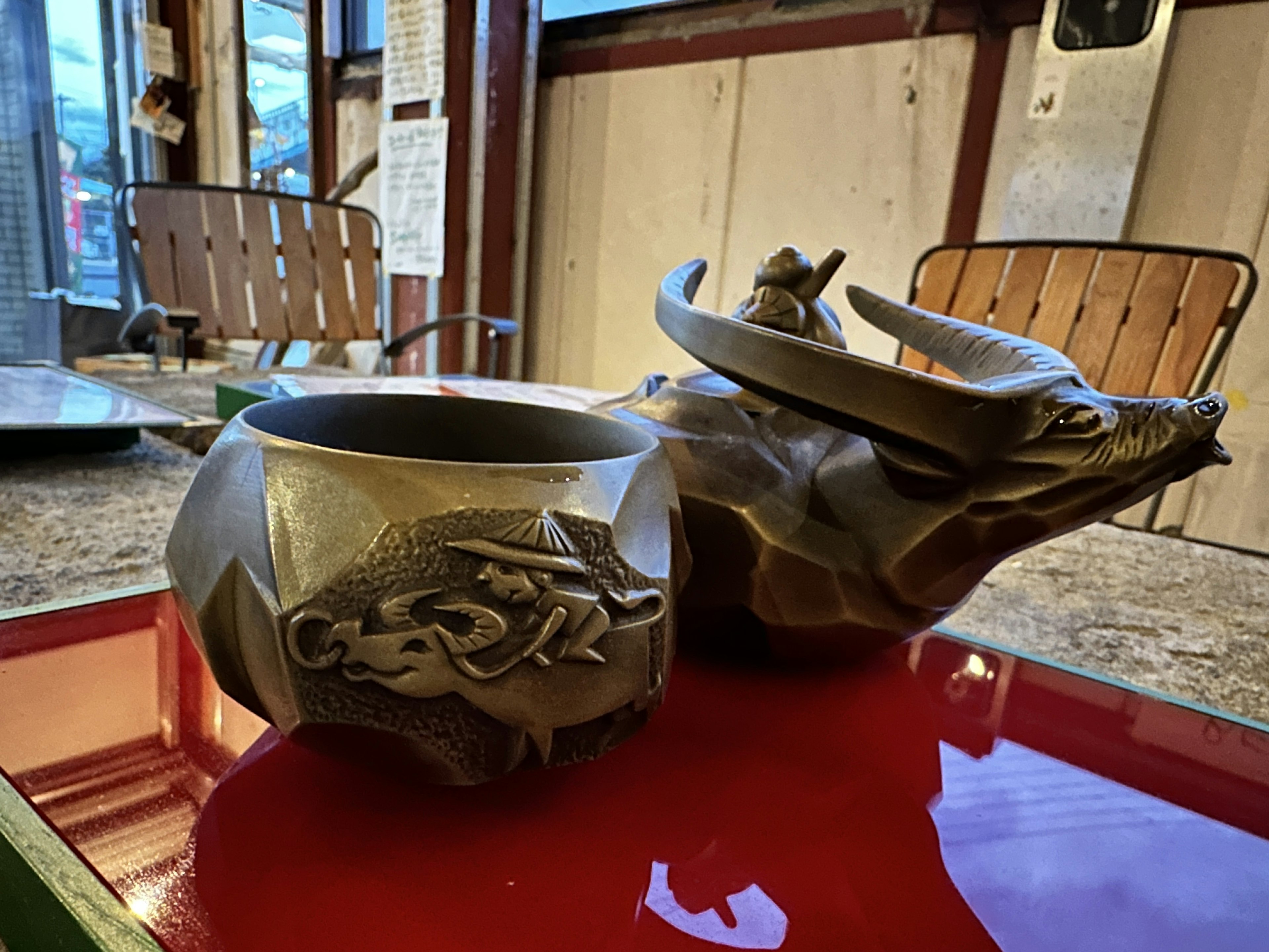 A ceramic bull-shaped pot and a decorative bowl placed on a table