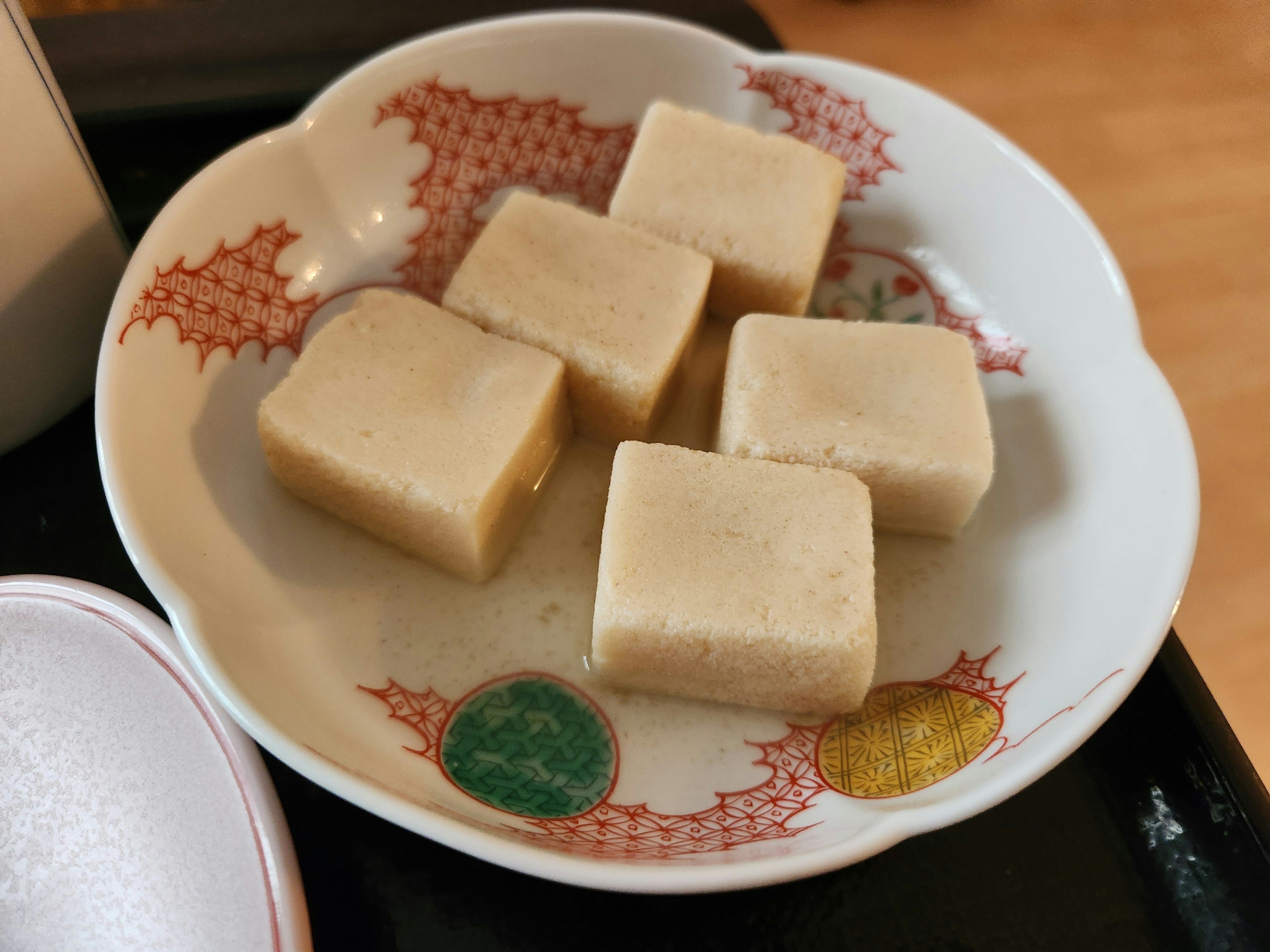 Five square pieces of traditional Japanese sweets on a decorative plate