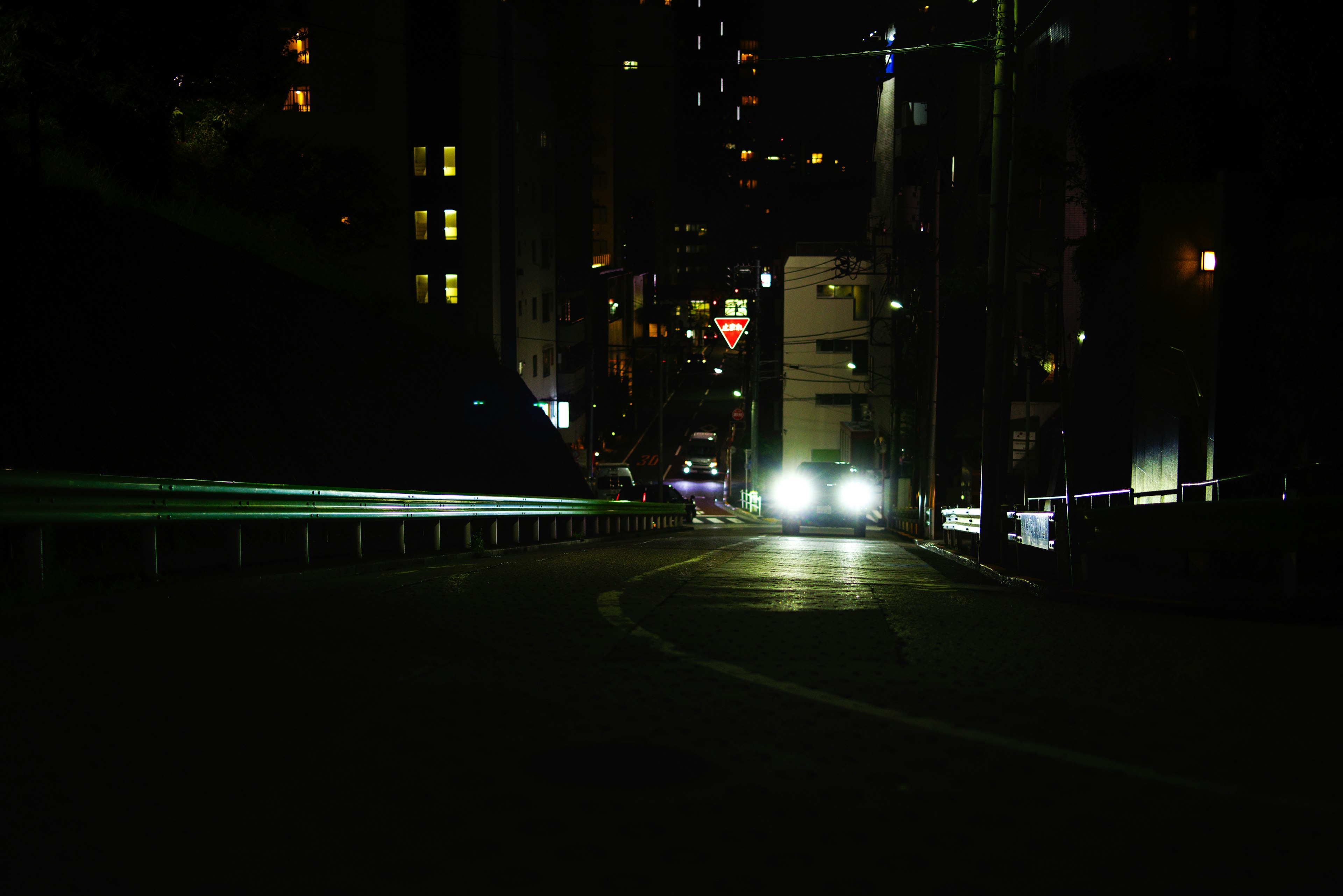 汽車大燈在夜晚的黑暗城市道路上閃爍