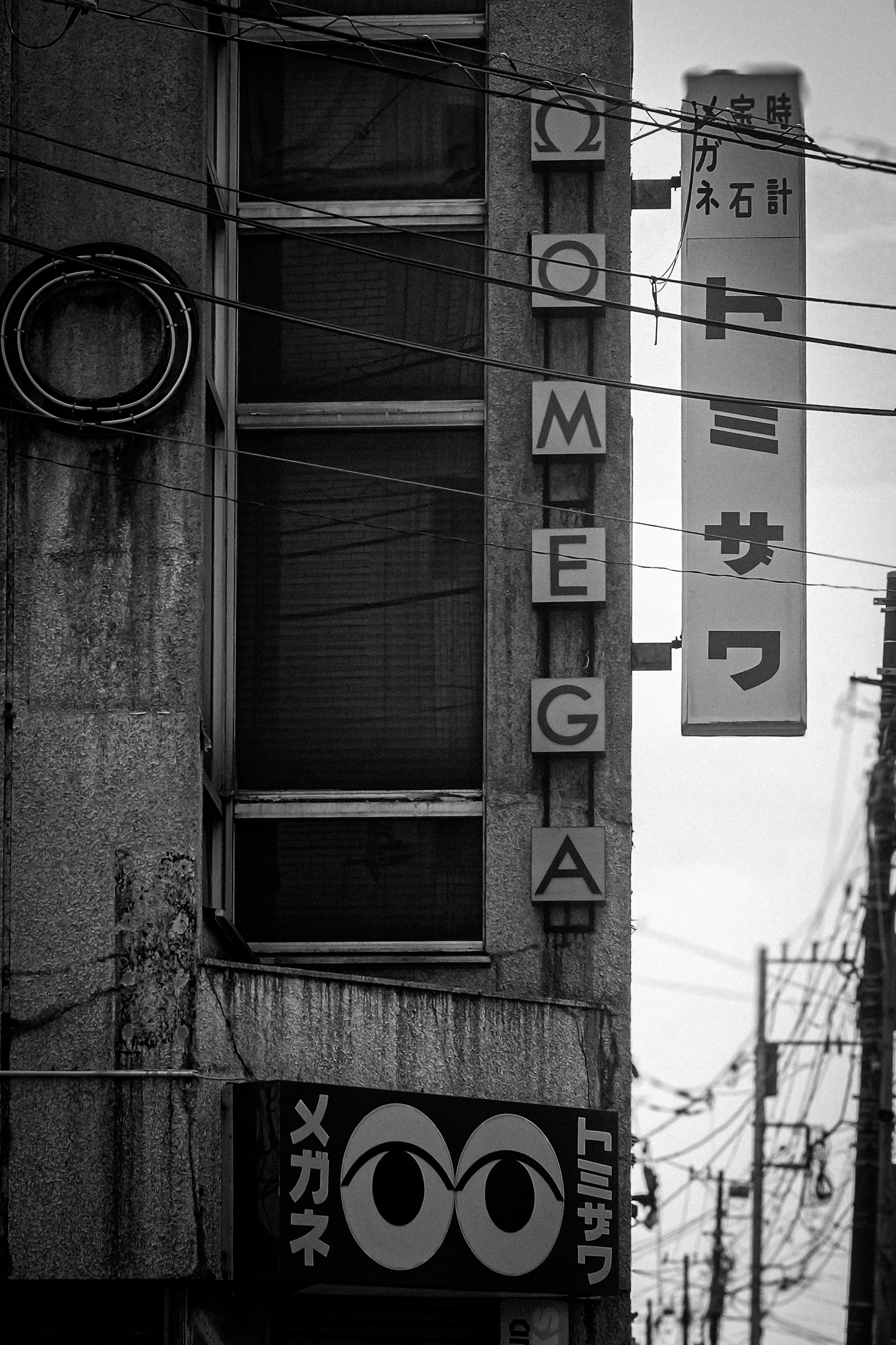 Mur de bâtiment avec enseigne Omega et texte en japonais