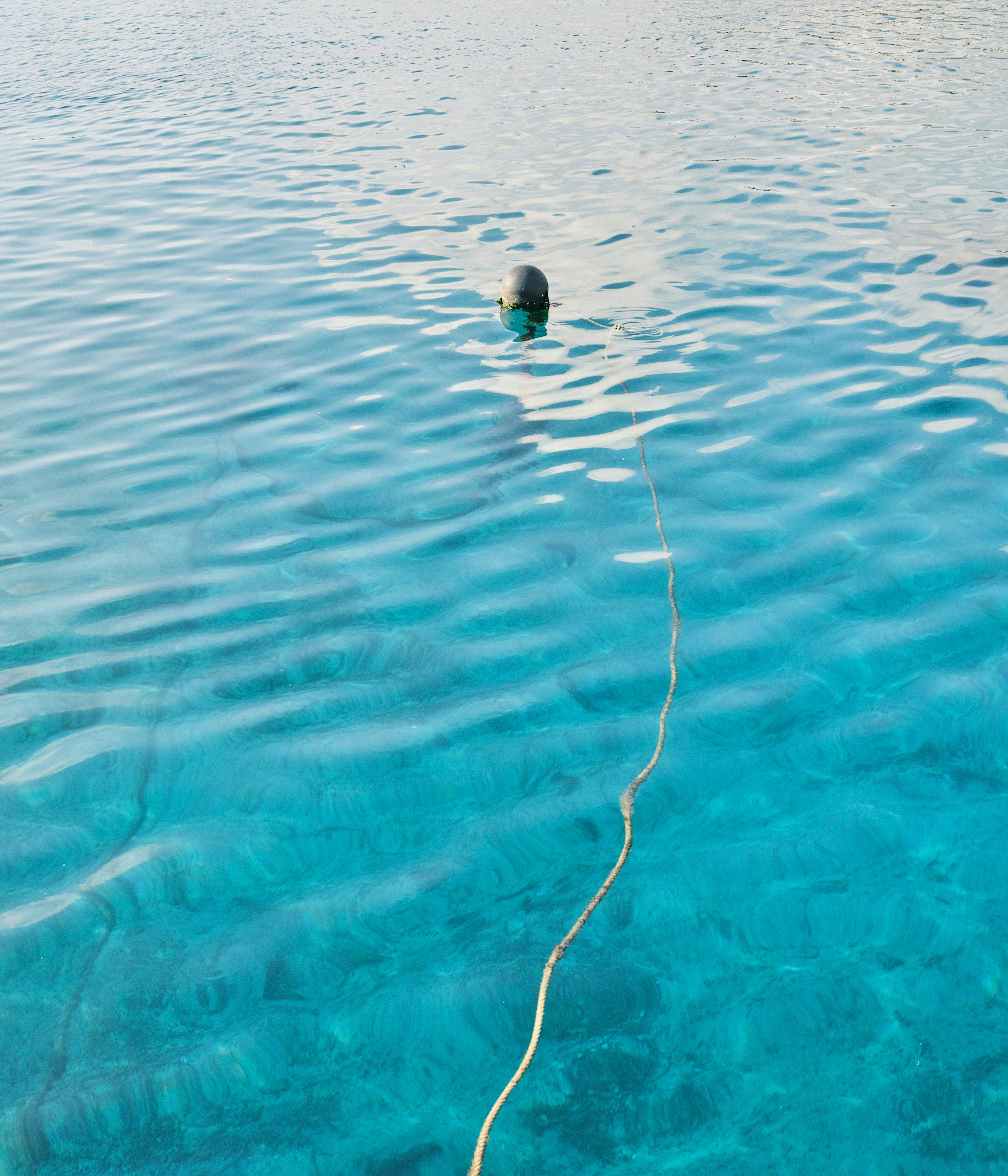 Objeto flotando en la superficie de agua clara con una cuerda larga