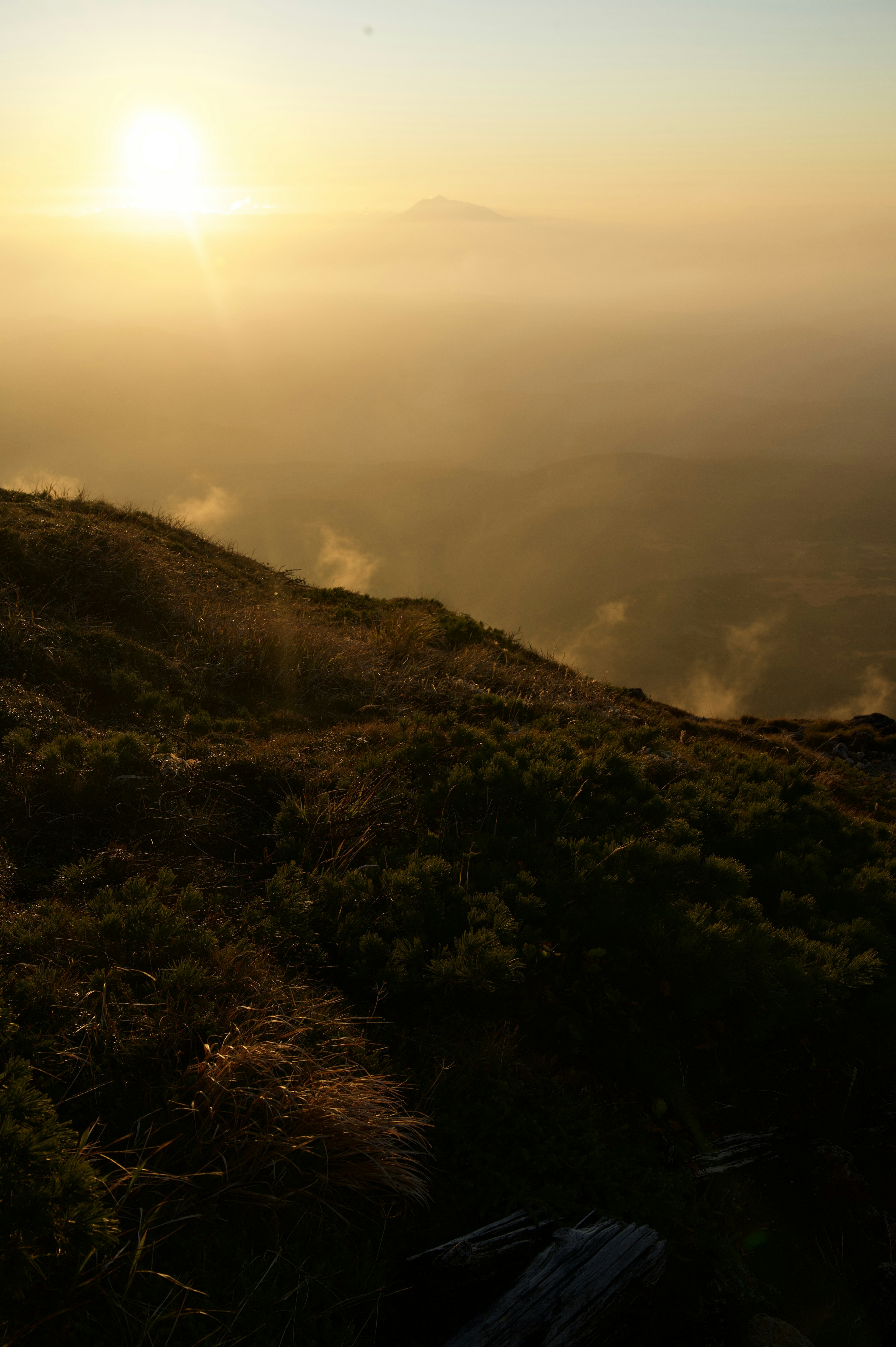 Malersicher Blick auf den Sonnenaufgang über sanften Hügeln und fernen Bergen