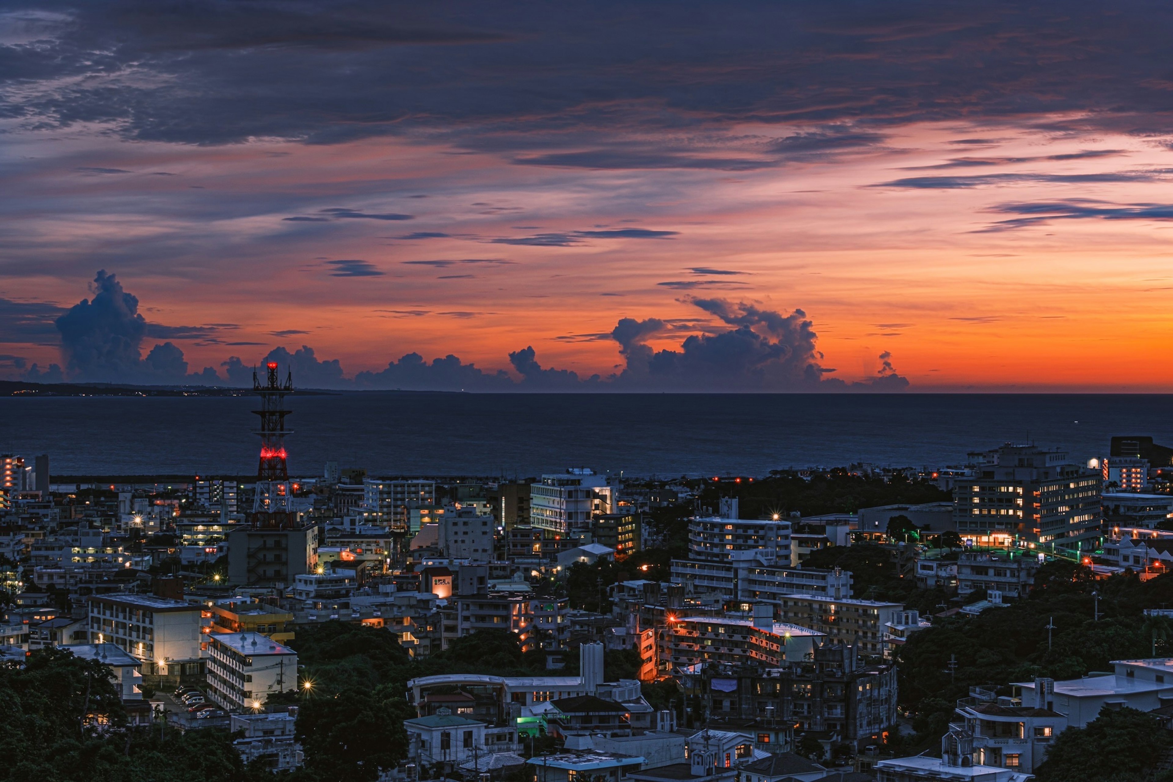 城市全景，背景是美丽的日落天空和海洋