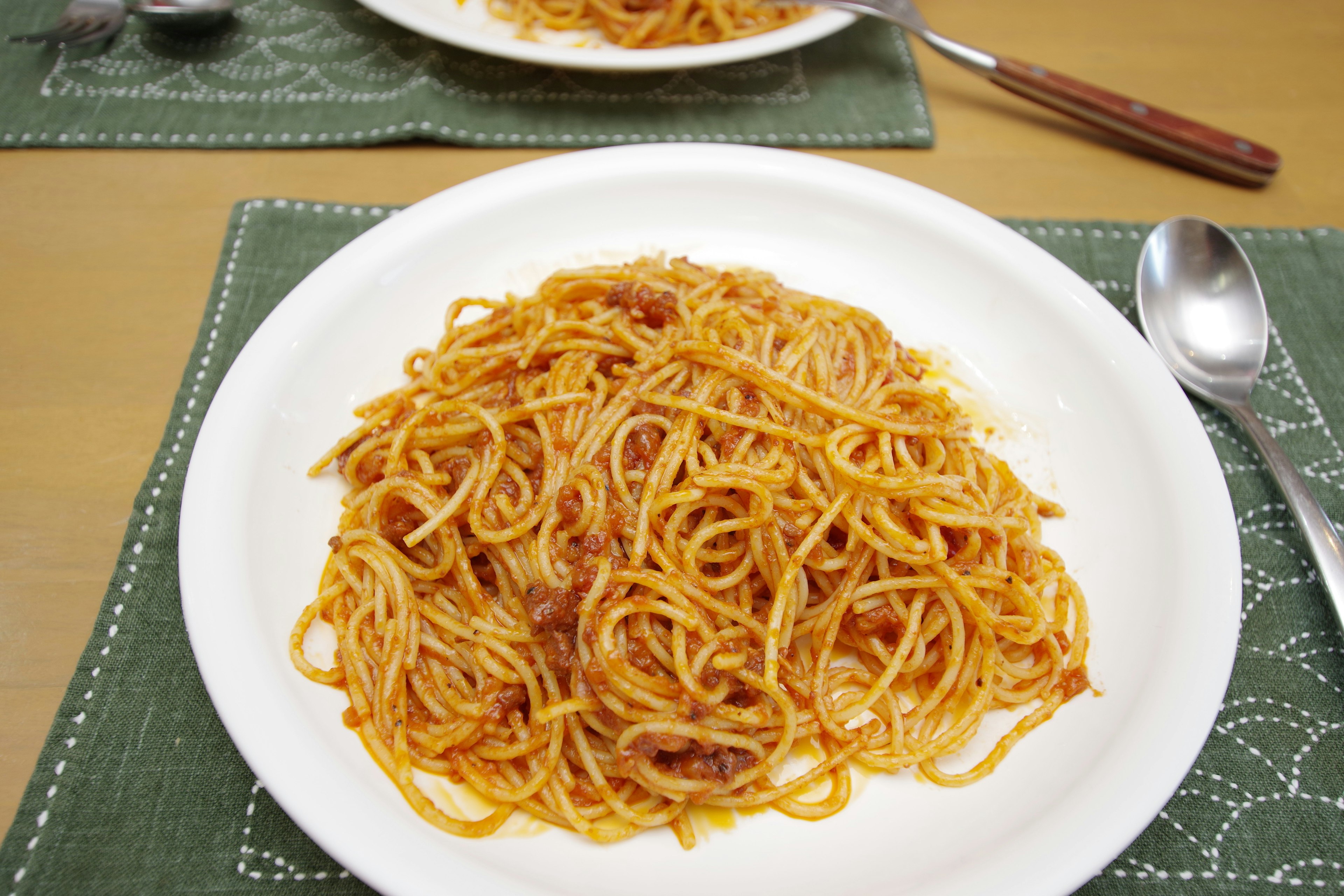 Spaghetti dengan saus tomat disajikan di piring putih