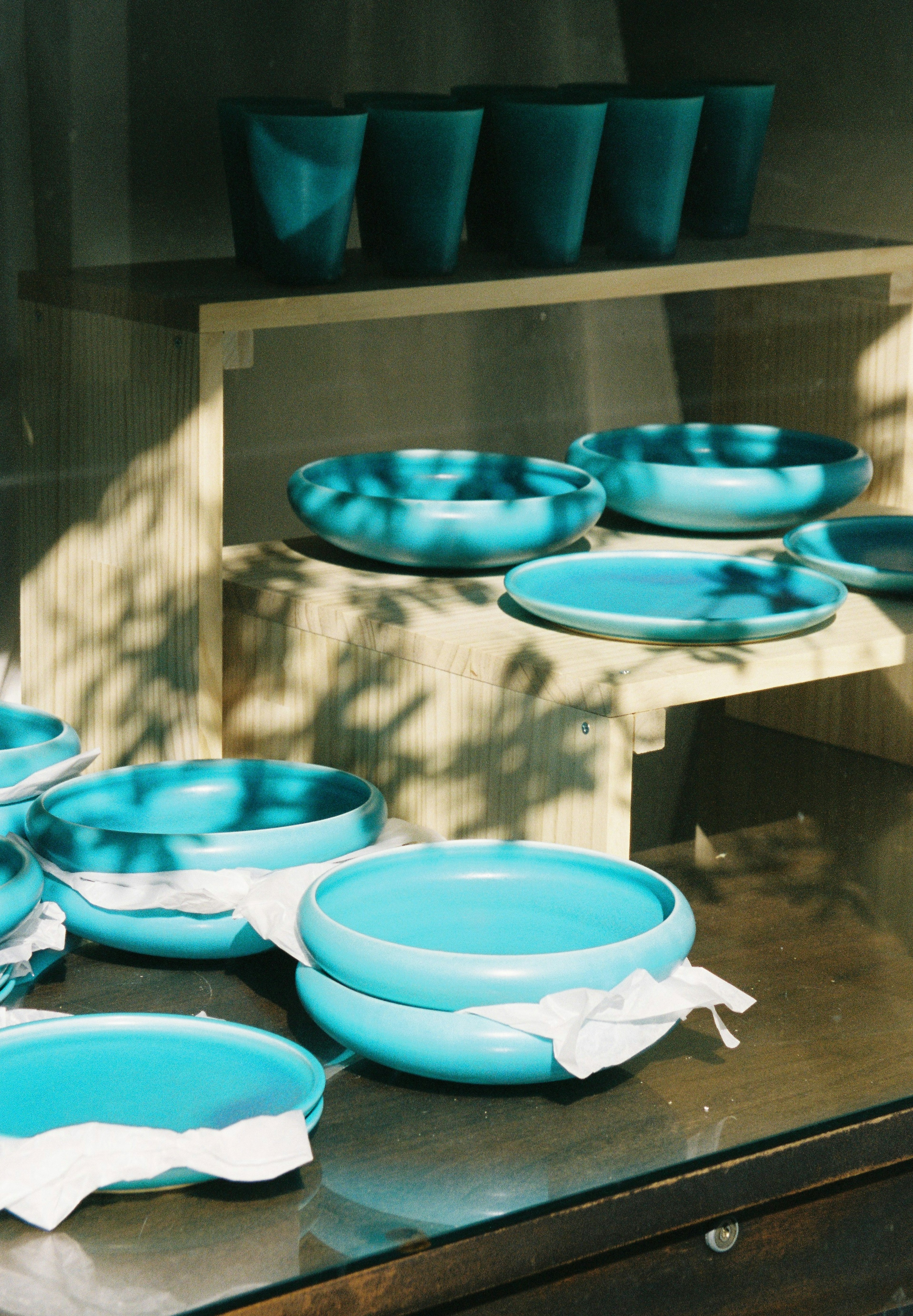 Display of turquoise plates and cups with soft shadows