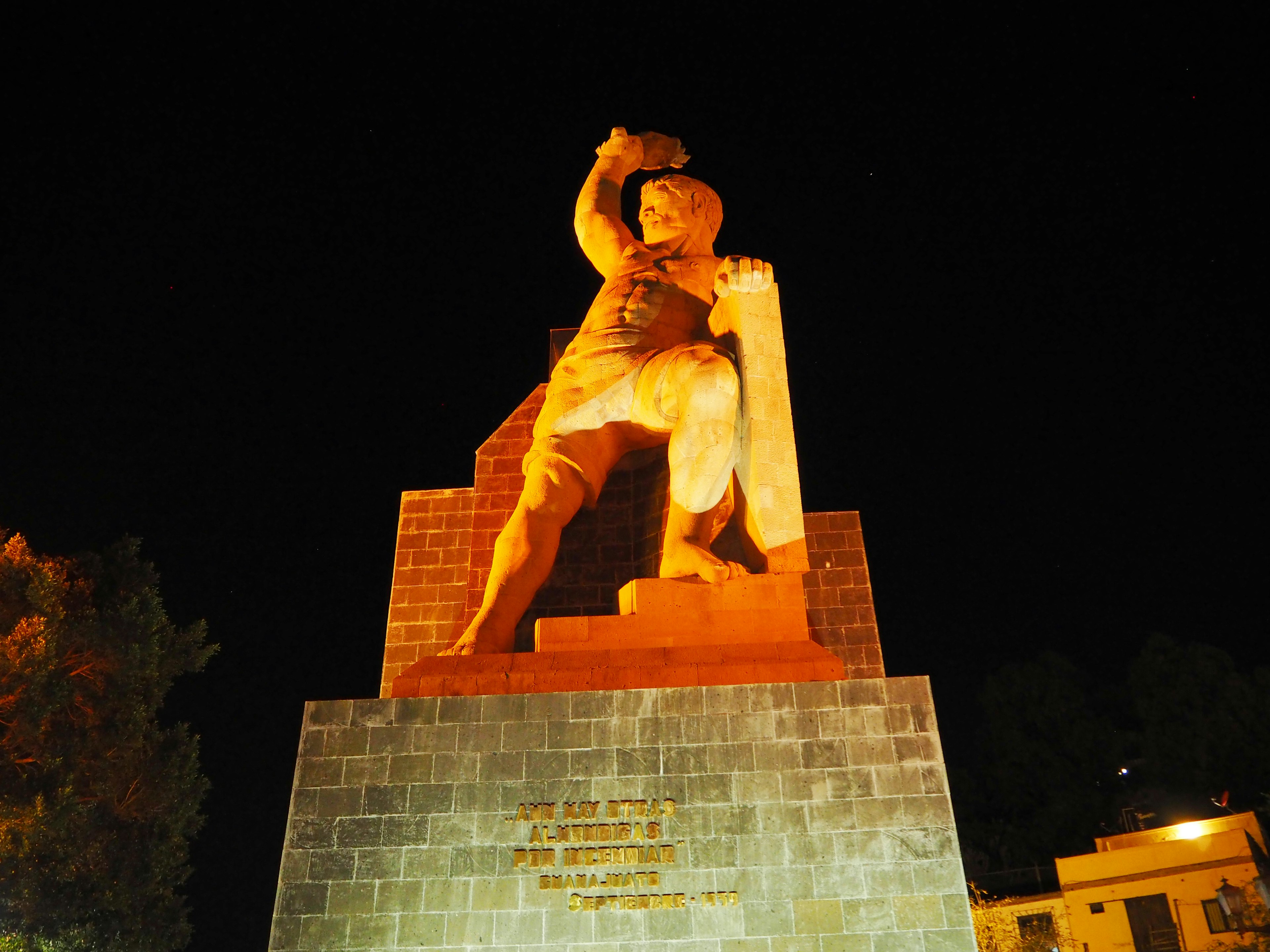 Una grande statua illuminata di notte raffigura un guerriero coraggioso