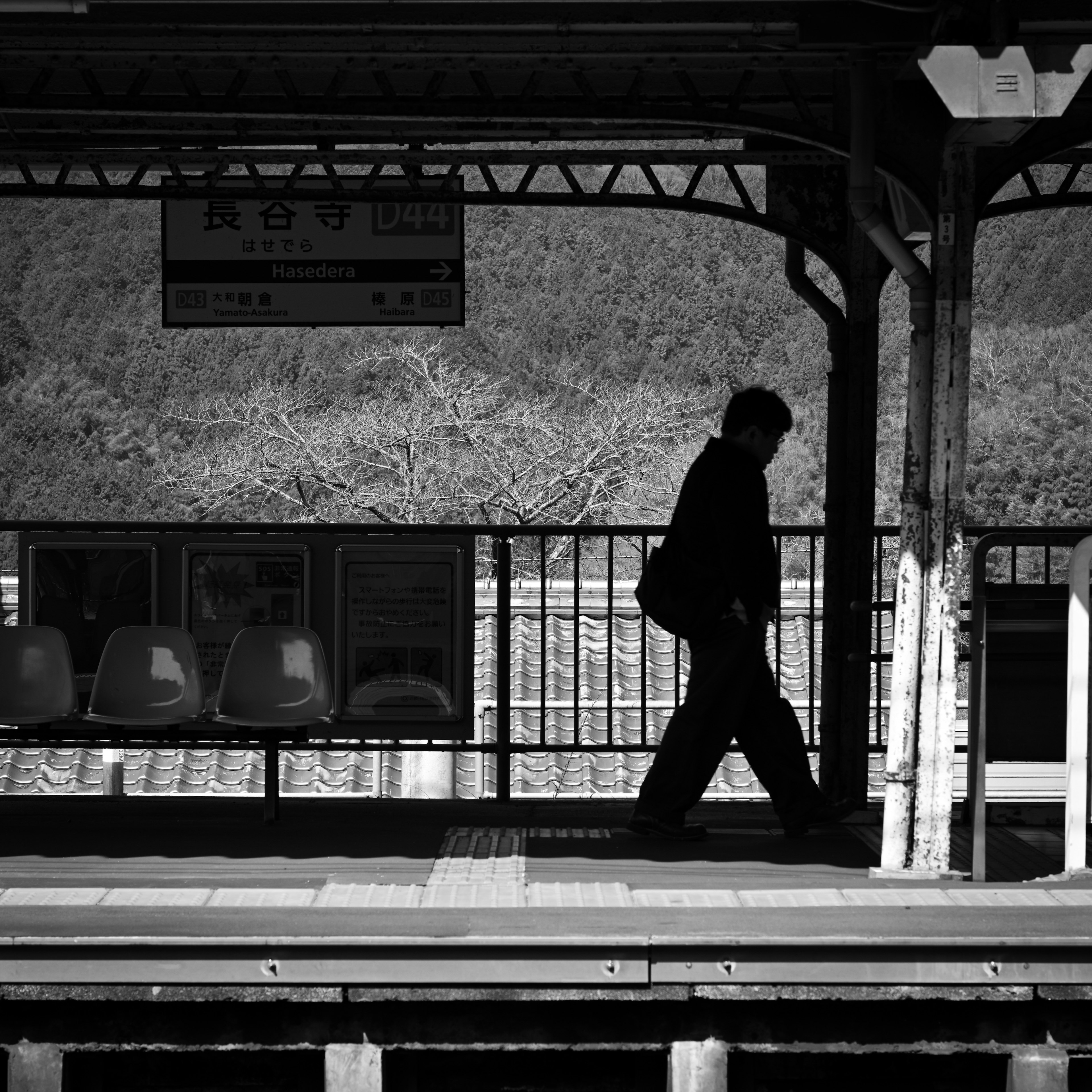 Silhouette di una persona che cammina su una piattaforma ferroviaria