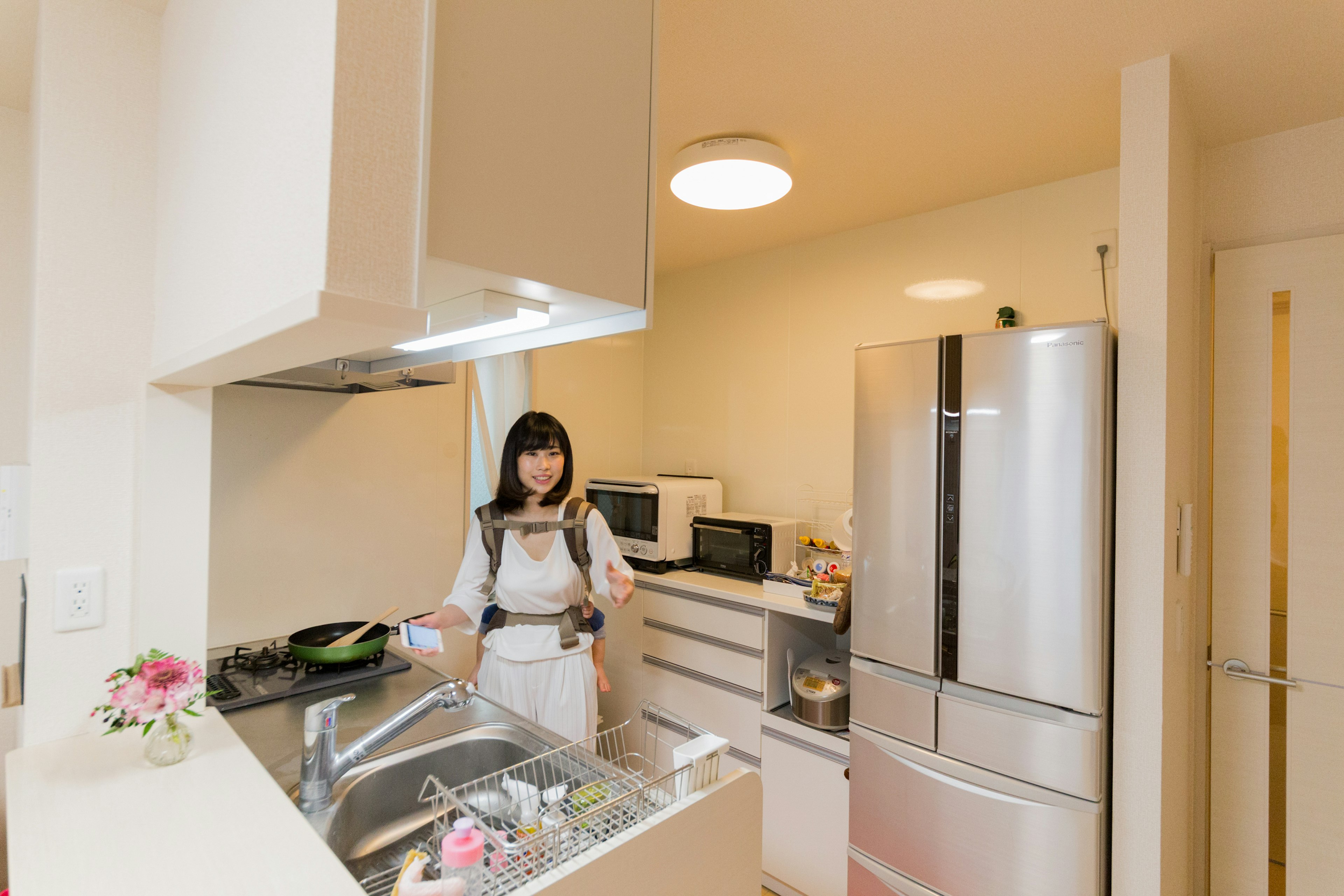 Una mujer cocinando en una cocina brillante con electrodomésticos modernos