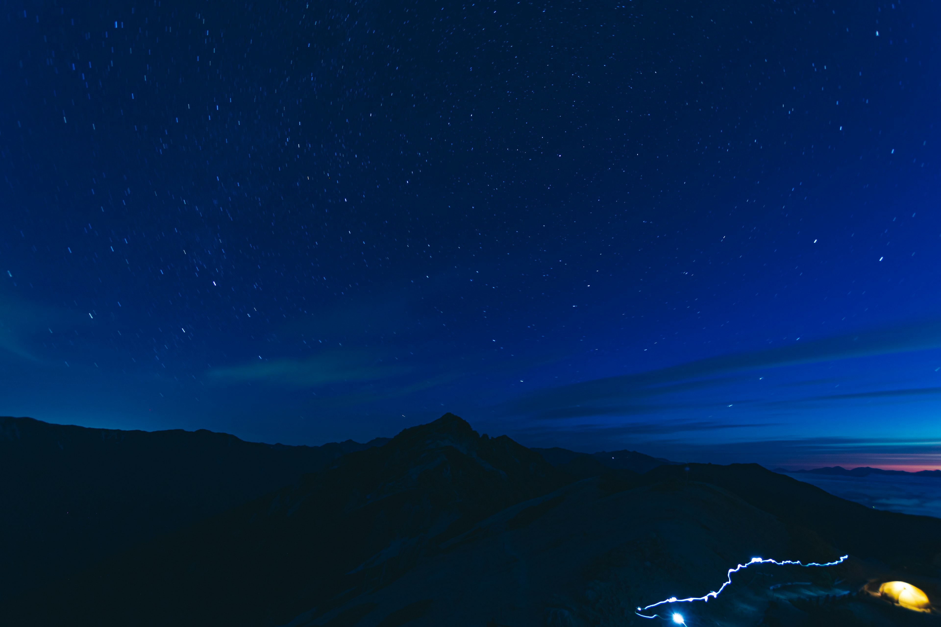 Cielo notturno pieno di stelle e silhouette di montagne