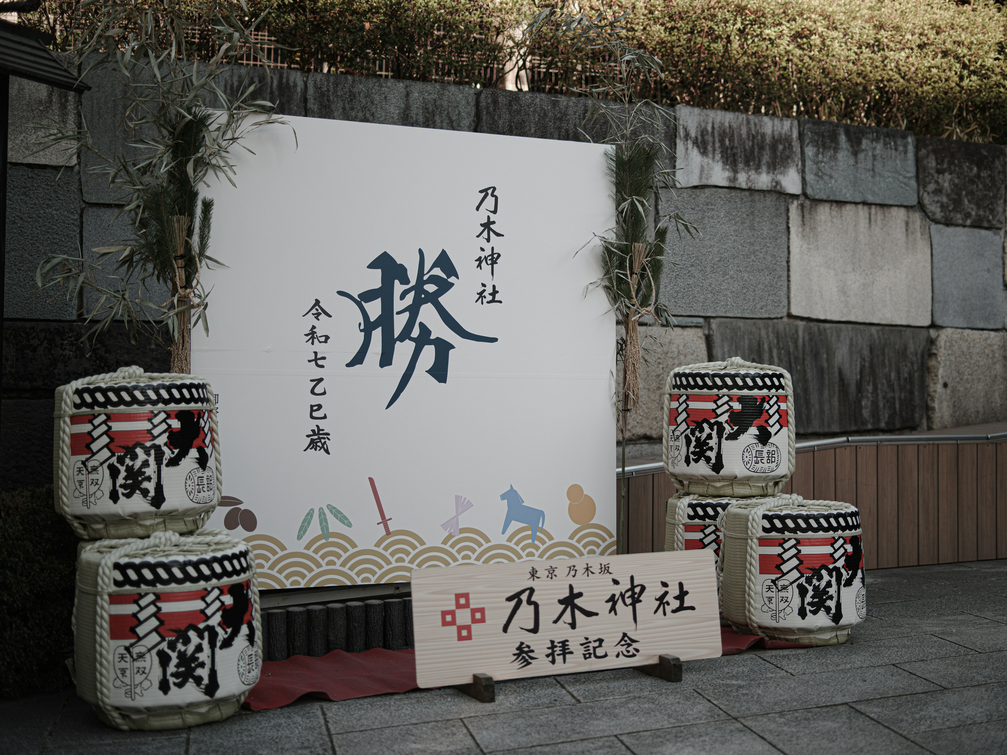 神社の入口にある装飾的な看板と酒樽