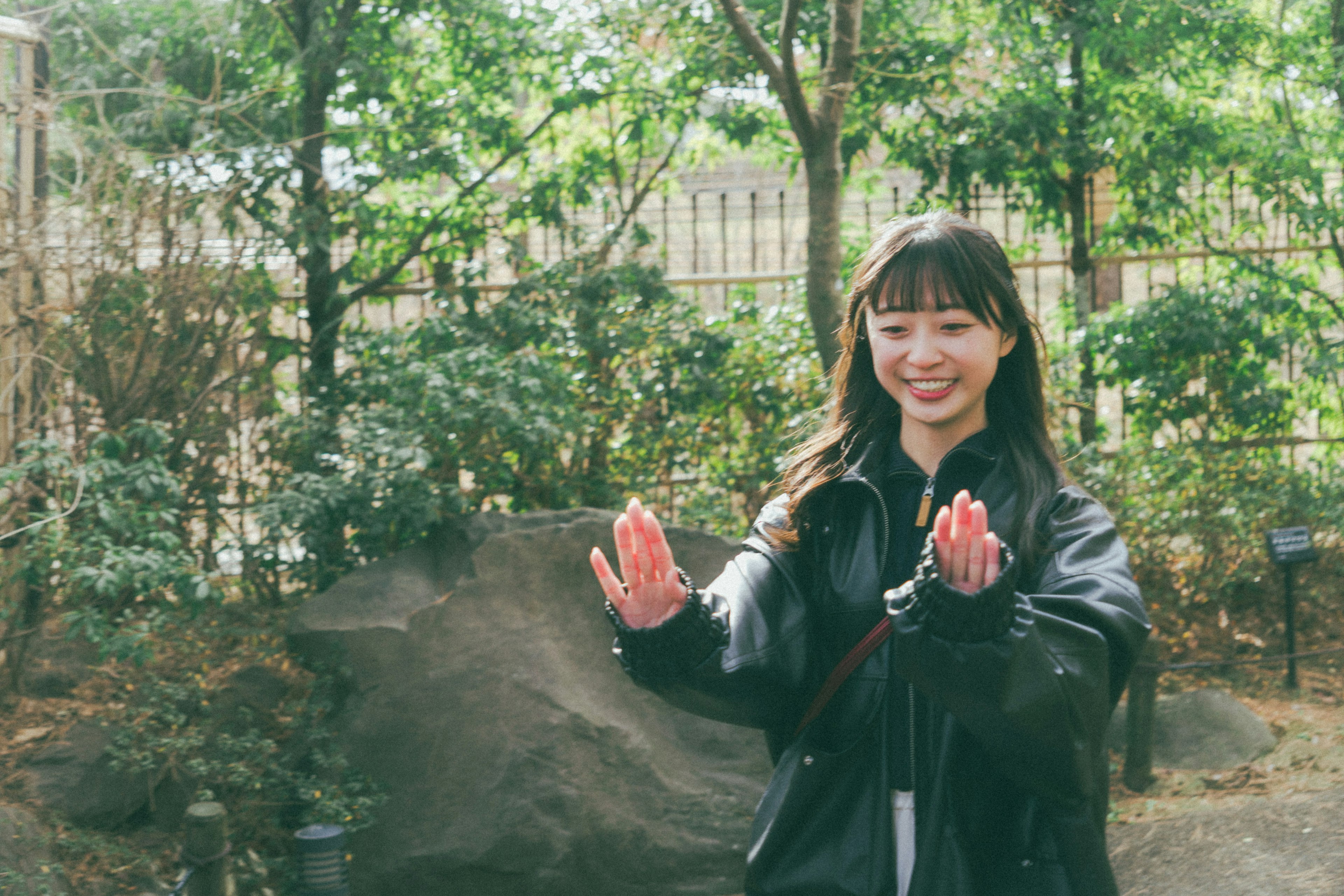 公園で手を広げて笑顔を見せる女性の写真