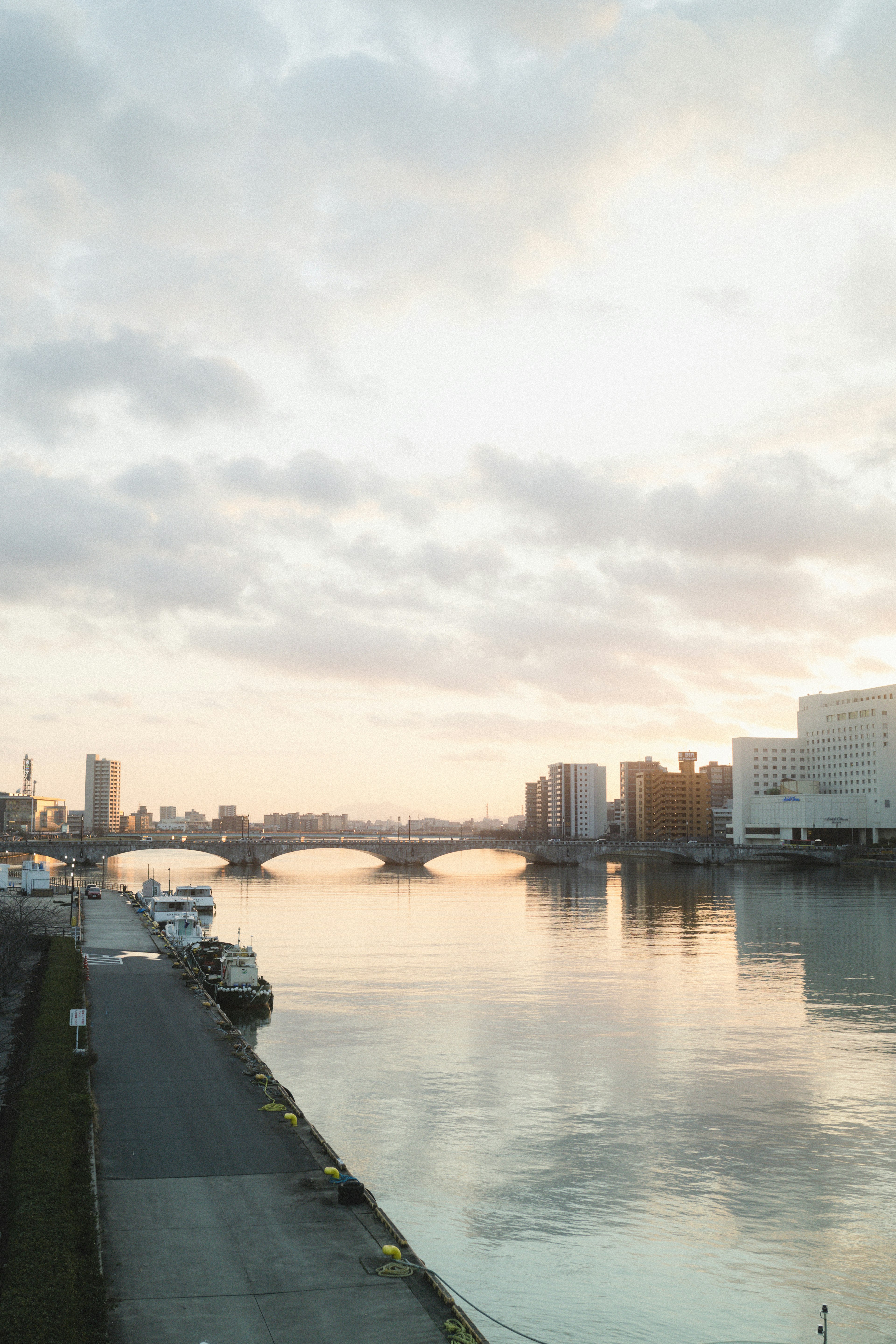 Vista escénica del río con un puente y cielo al atardecer