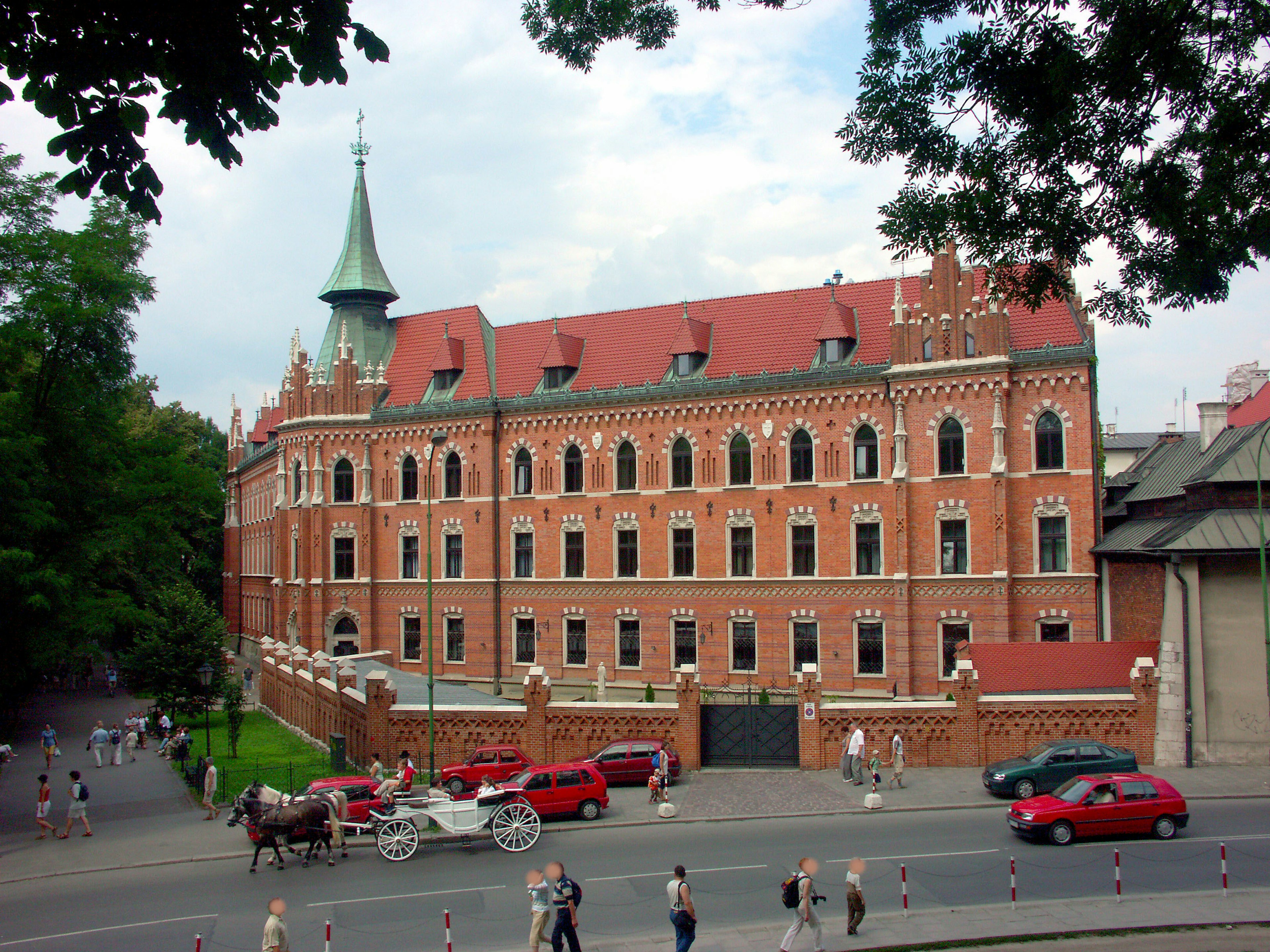 Rotes Backsteingebäude mit grünen Bäumen im Hintergrund