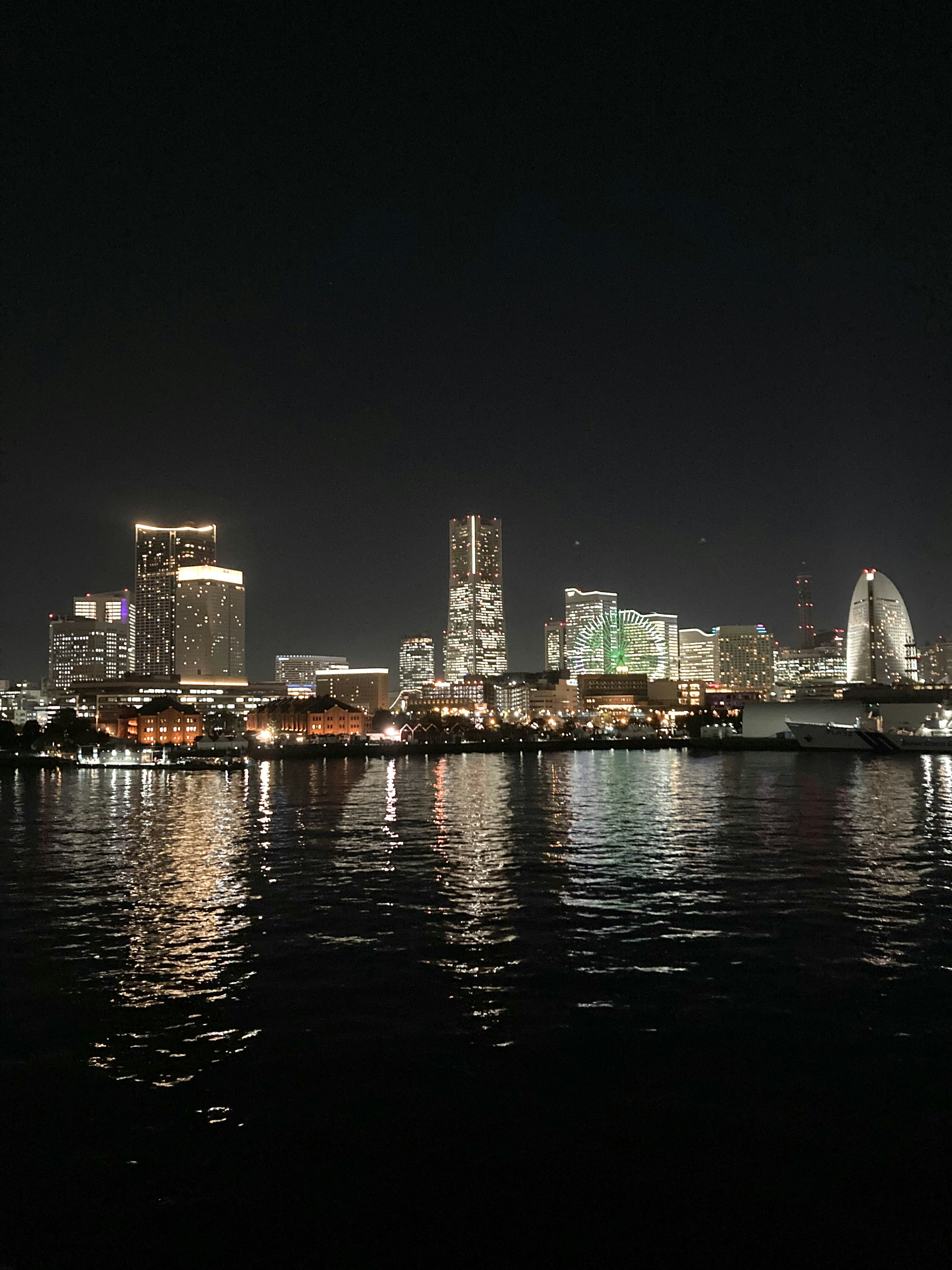 Horizonte de Yokohama de noche con reflejos en el agua