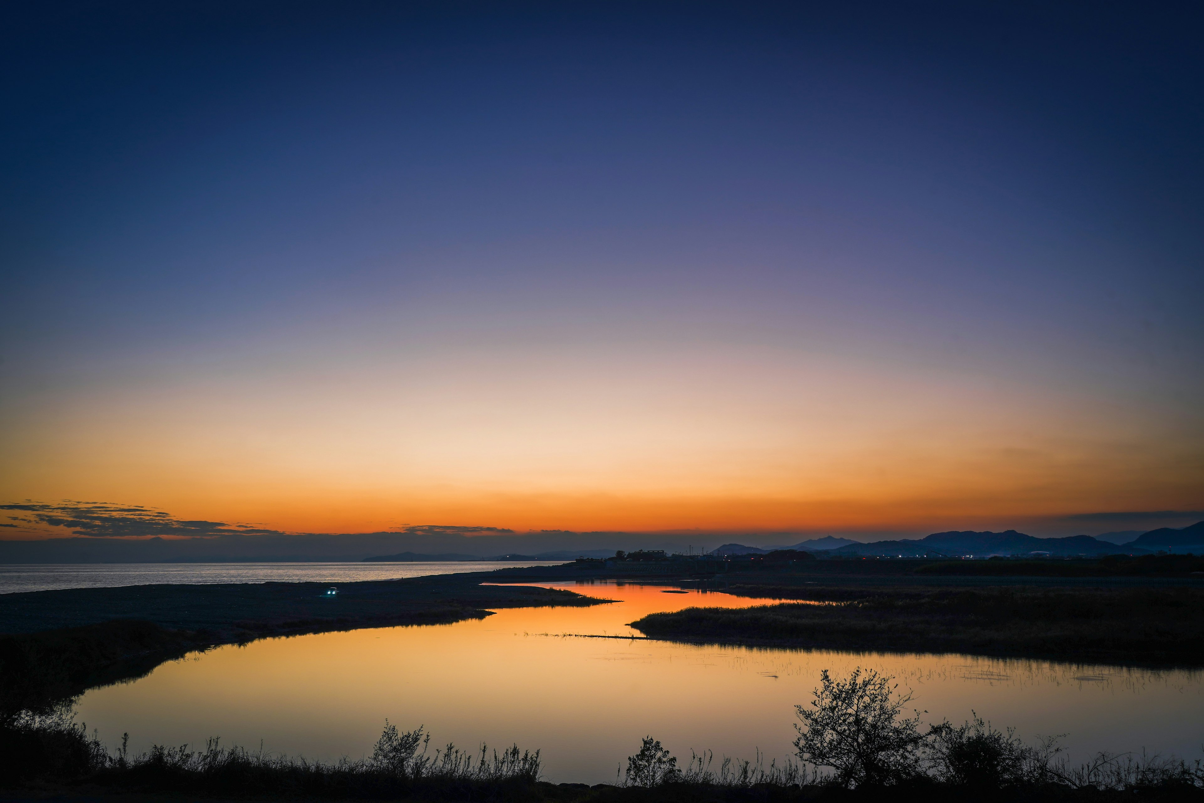 美しい夕焼けの風景で、川が平和に流れています