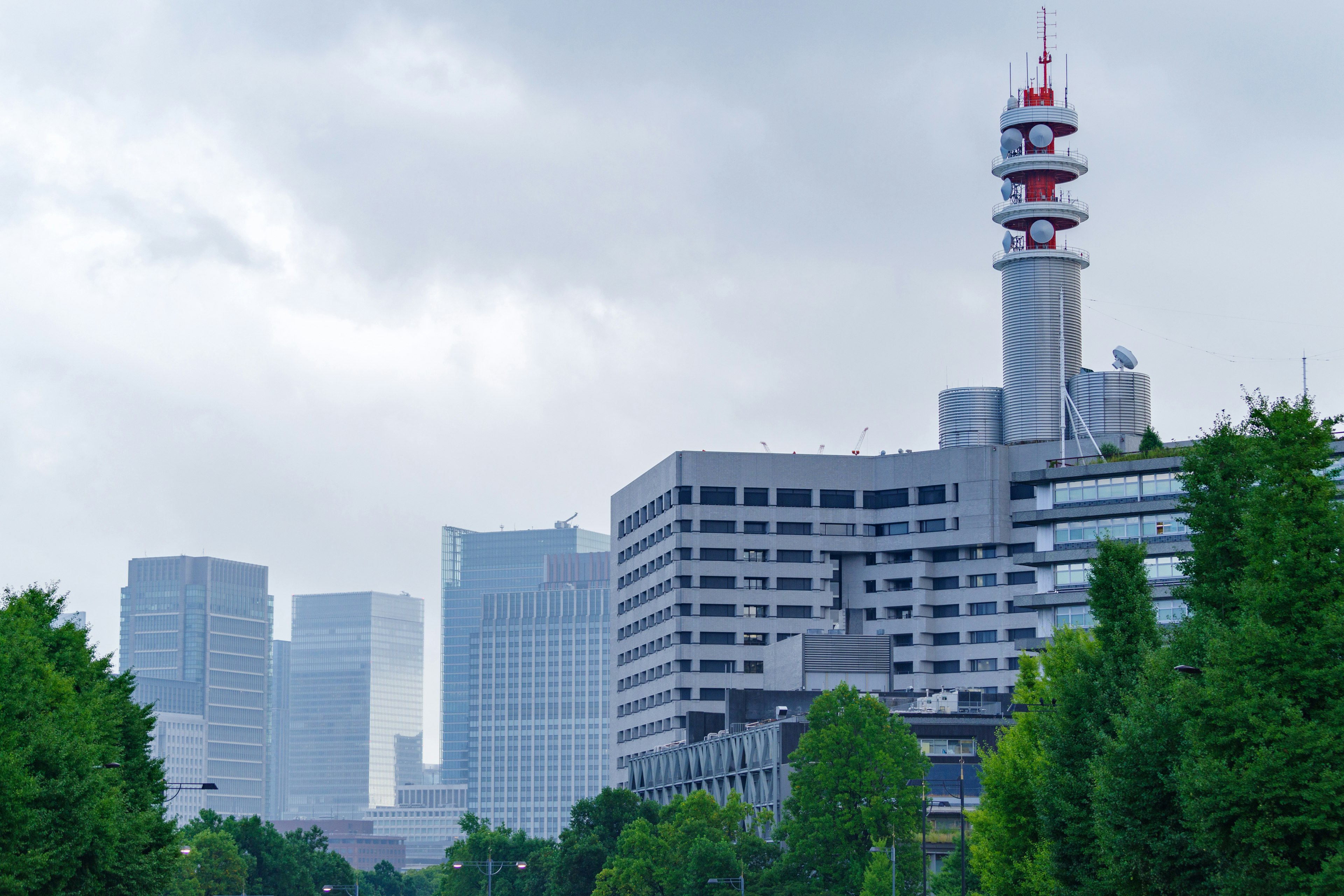 Skyline cittadina con edifici e torre di comunicazione in una giornata nuvolosa